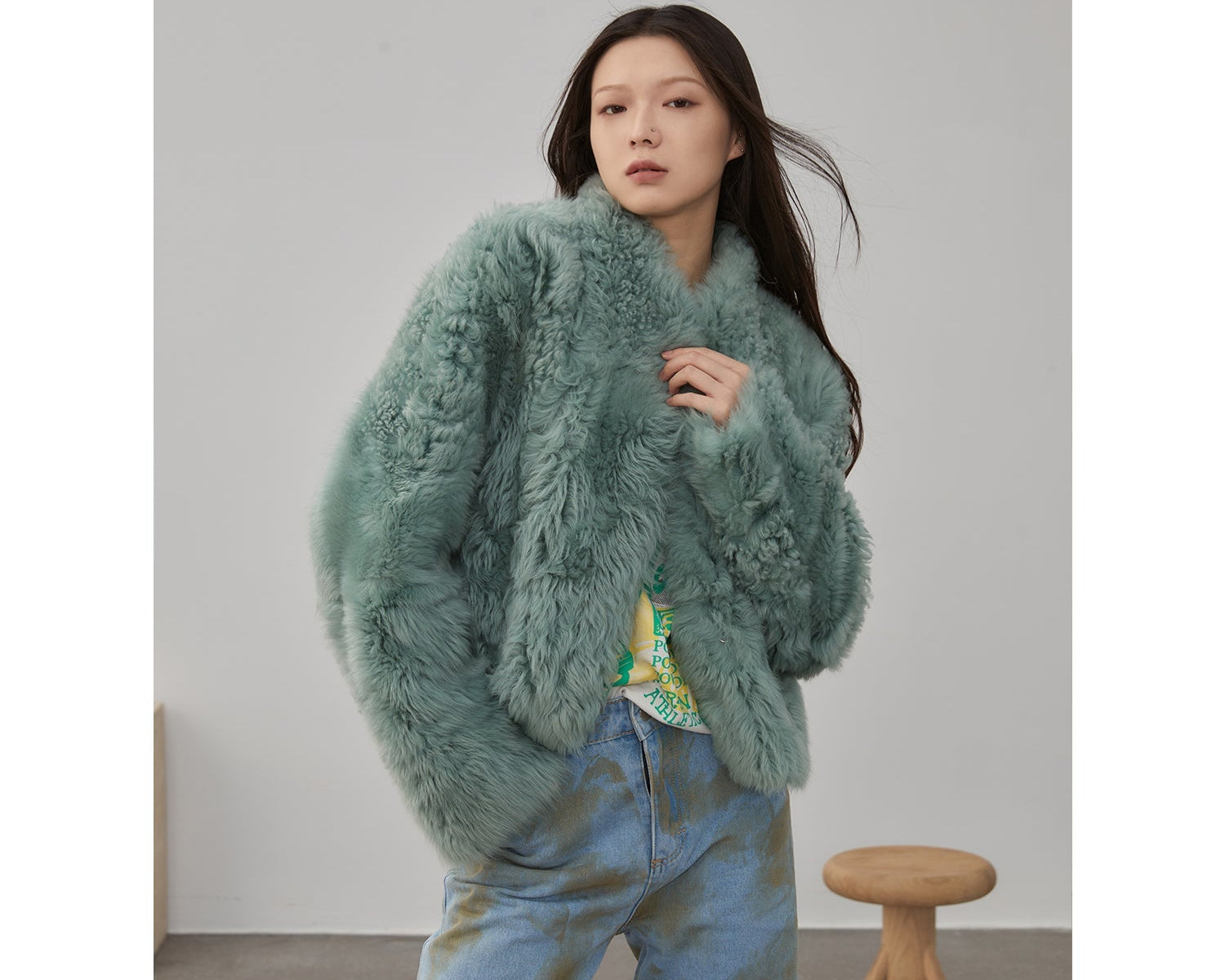 NEWYORKLISTED STYLE COLLECTION: Woman wearing a fluffy green sweater with a neutral background