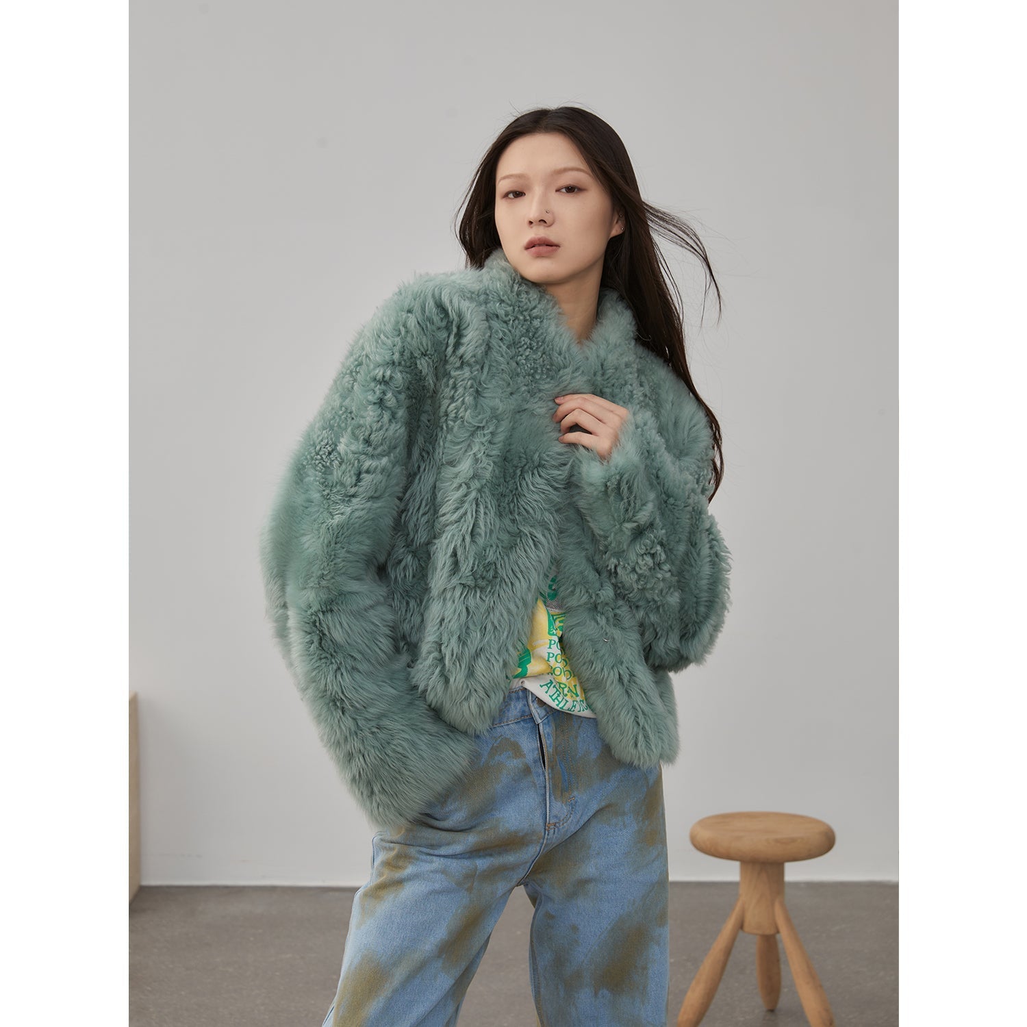 NEWYORKLISTED STYLE COLLECTION: Woman wearing a fluffy green sweater with a neutral background