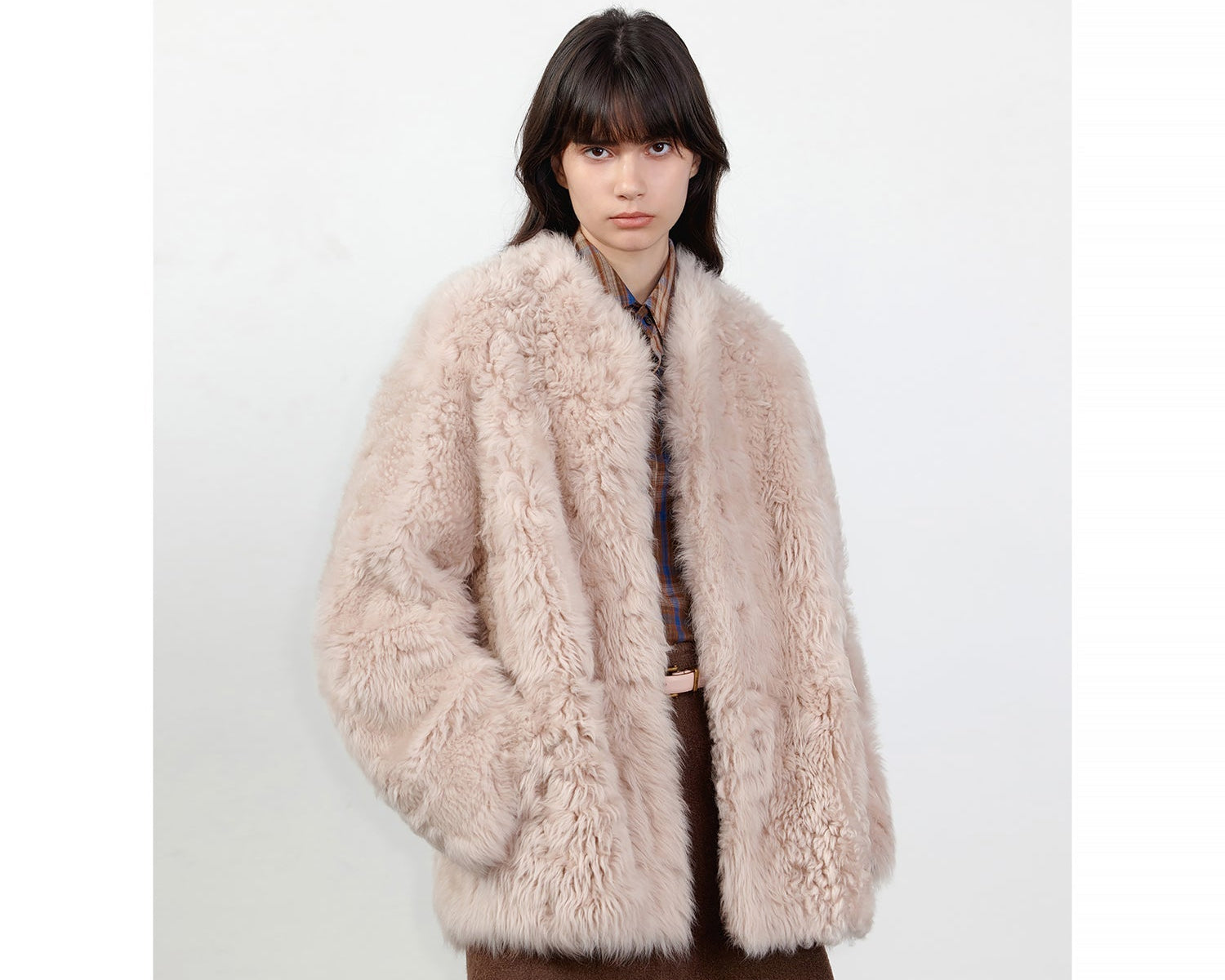NEWYORKLISTED STYLE COLLECTION: Person wearing a fluffy beige coat on a white background