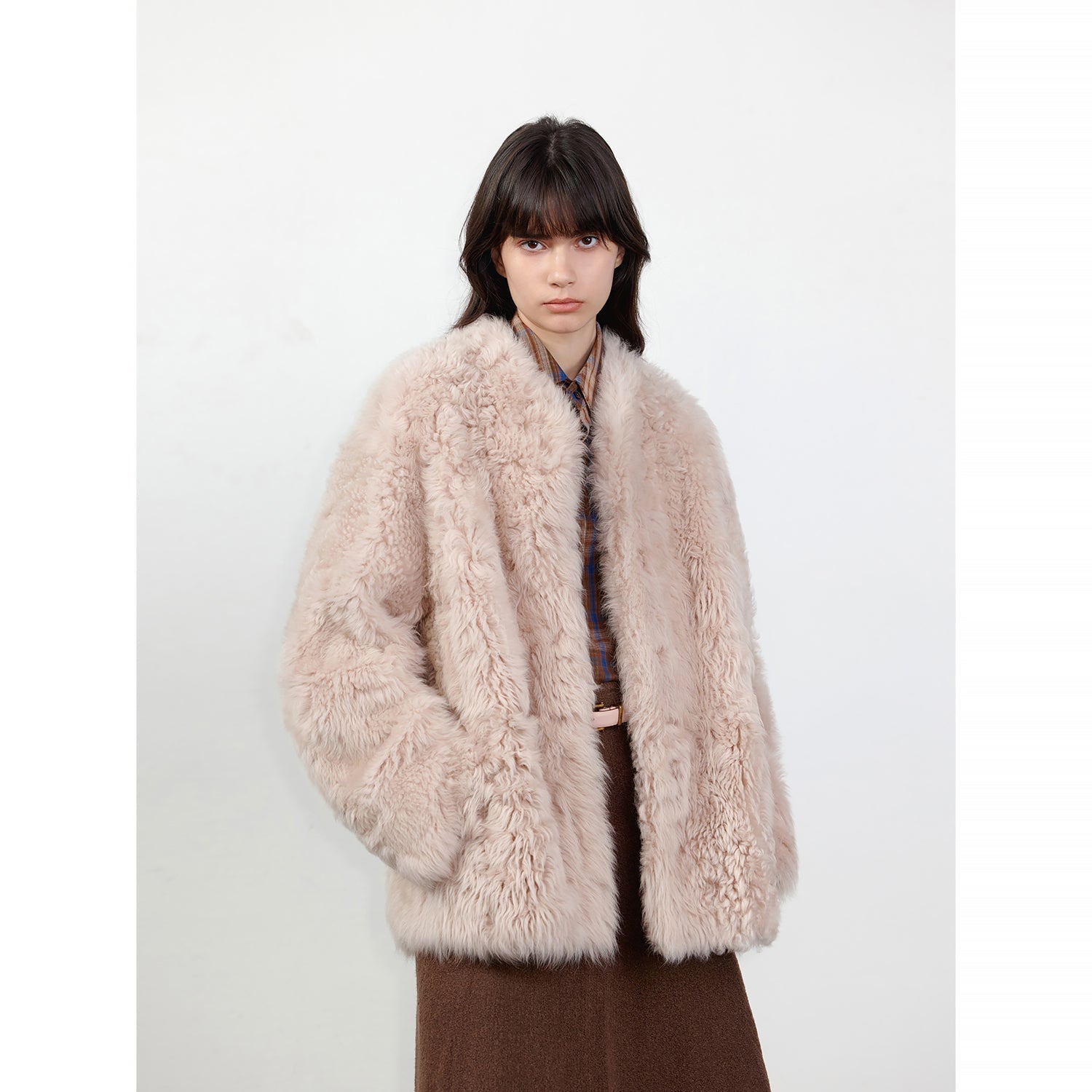 NEWYORKLISTED STYLE COLLECTION: Person wearing a fluffy beige coat on a white background