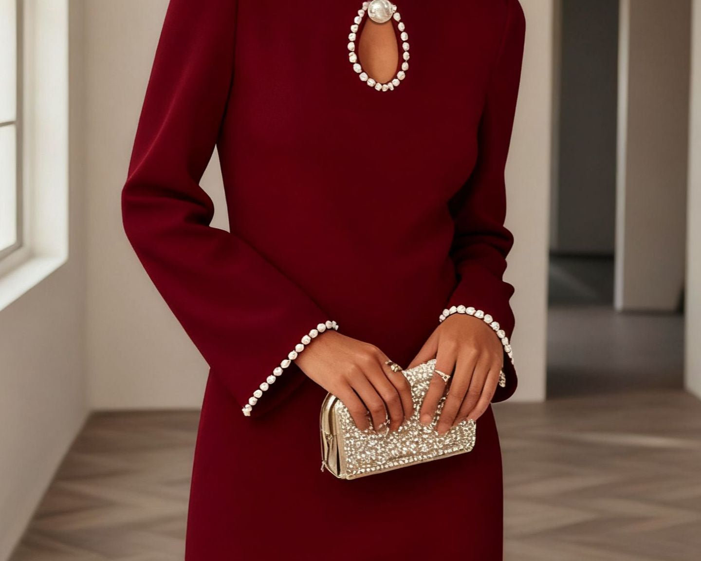 NEWYORKLISTED STYLE COLLECTION: Woman wearing a burgundy dress with pearl details holding a matching clutch.
