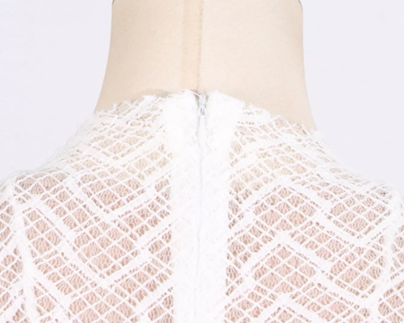 White lace garment on a mannequin with a gold top against a white background