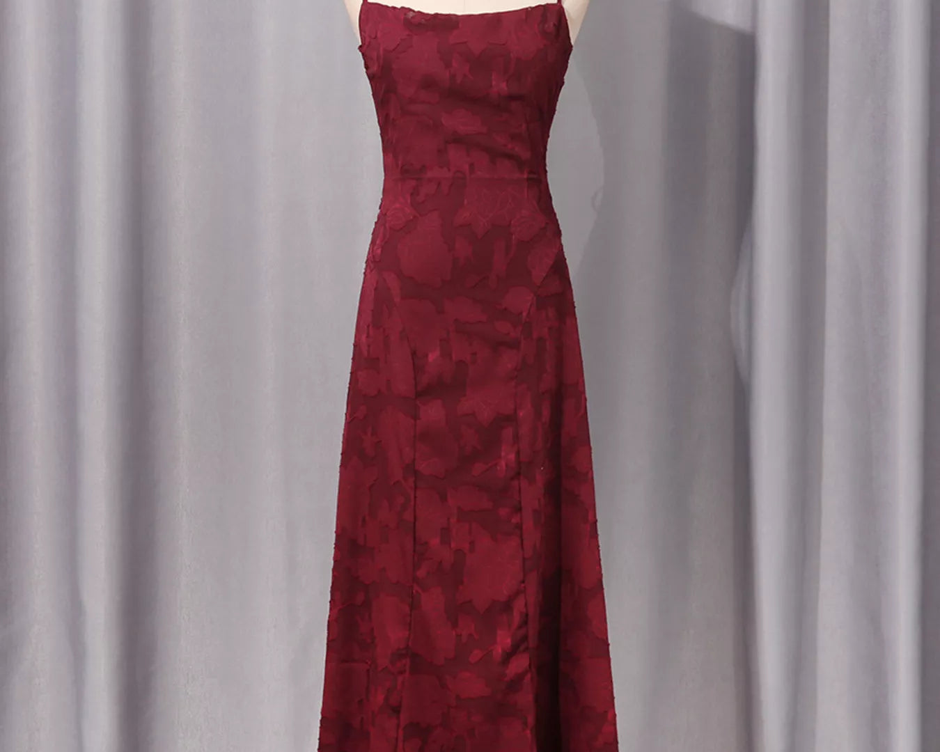 NEWYORKLISTED STYLE COLLECTION: Burgundy dress on a mannequin against a gray curtain background