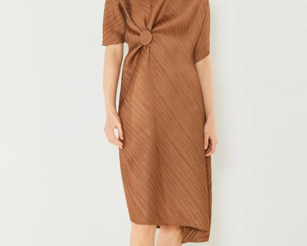 Woman wearing a brown dress with a knot detail on a white background: NEWYORKLISTED STYLE COLLECTION