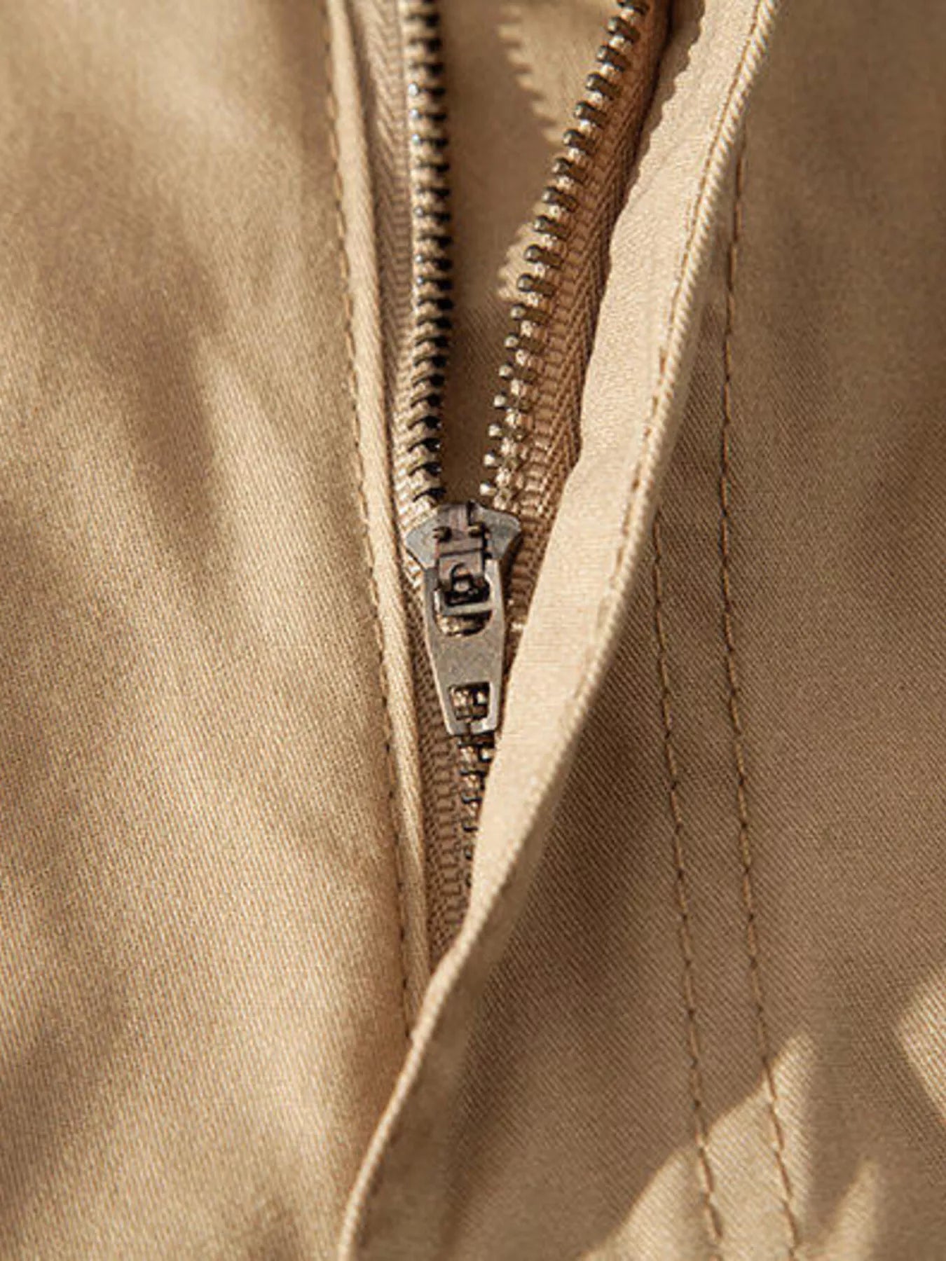 ATLAS MEN'S COLLECTION: Close-up of a beige jacket with a zipper