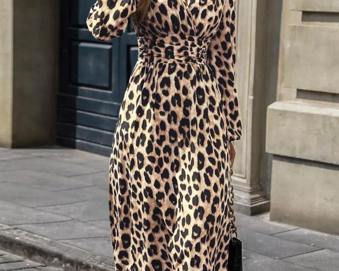 NEWYORKLISTED STYLE COLLECTION: Woman wearing a leopard print dress holding a coffee cup on a city street.