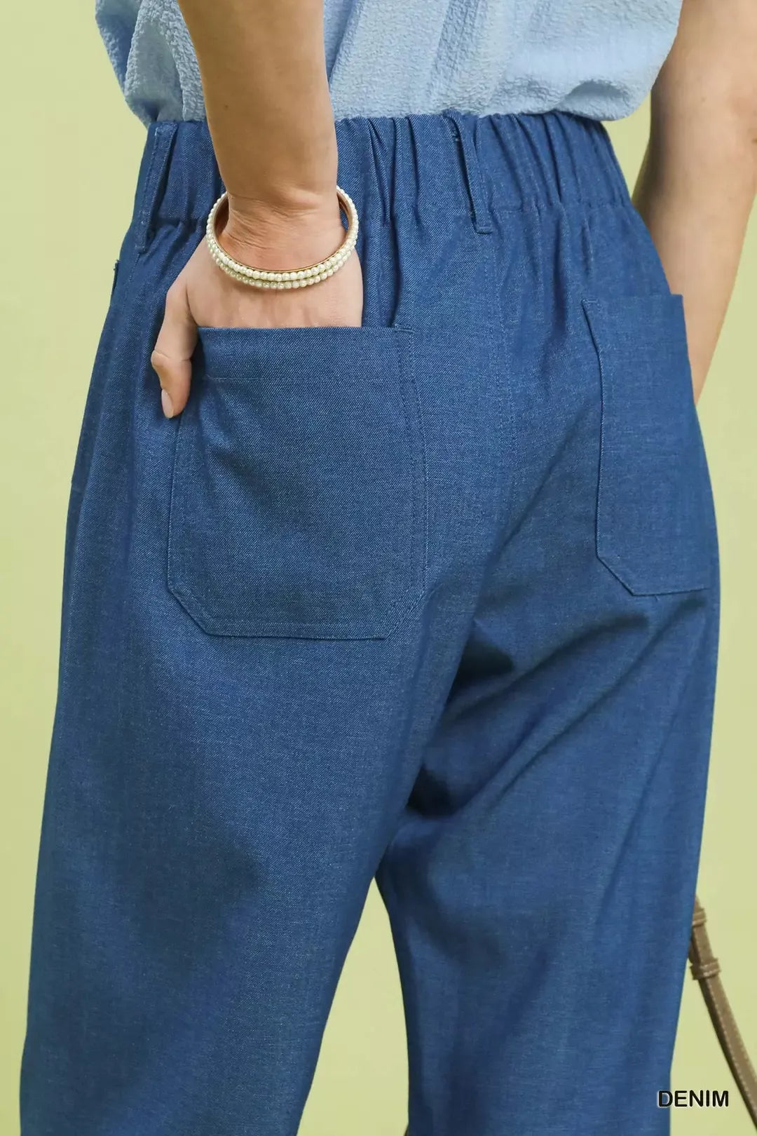 NEWYORKLISTED Style Collection: Blue denim pants with a light green background