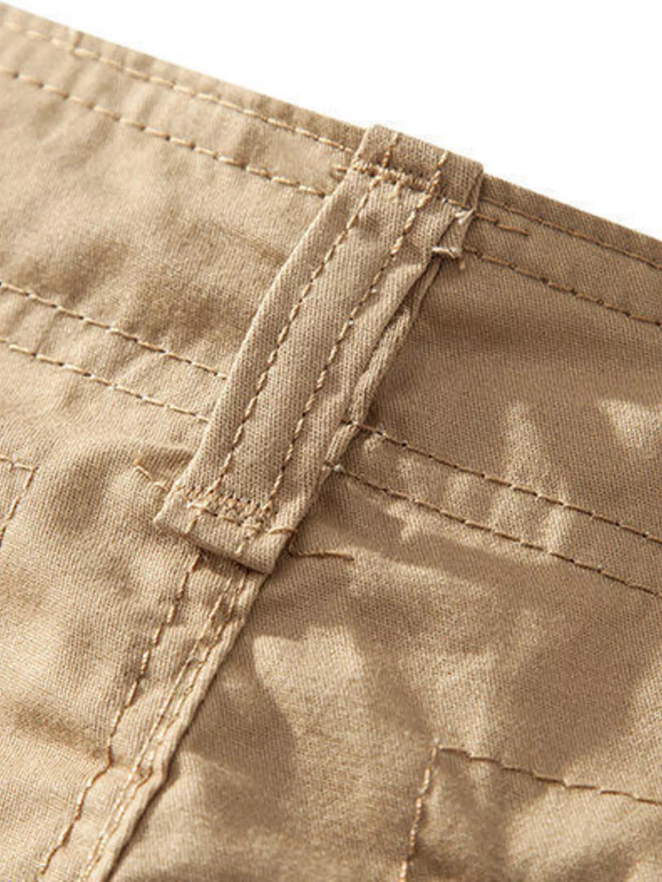 ATLAS MEN'S COLLECTION: Close-up of beige pants with stitching detail