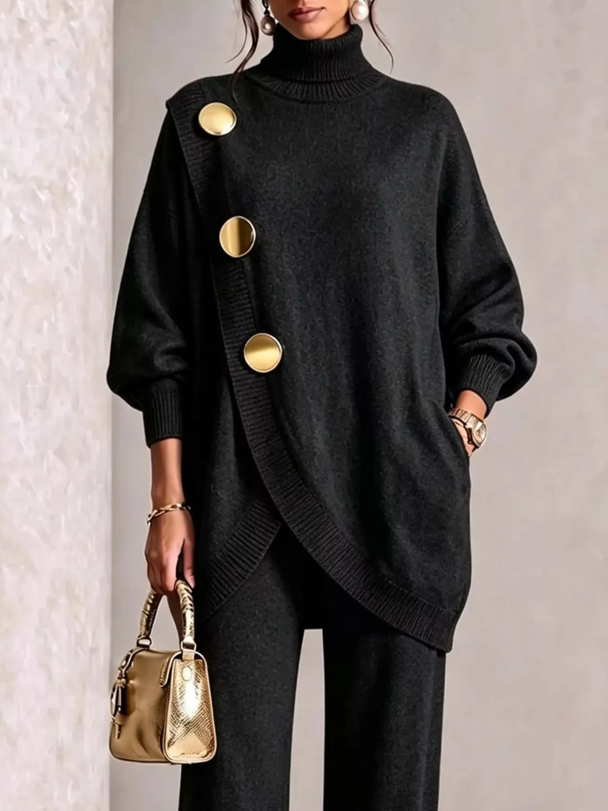 NEWYORKLISTED STYLE COLLECTION: A woman models a black oversized turtleneck sweater with asymmetrical gold buttons, paired with black pants and holding a small metallic gold handbag.