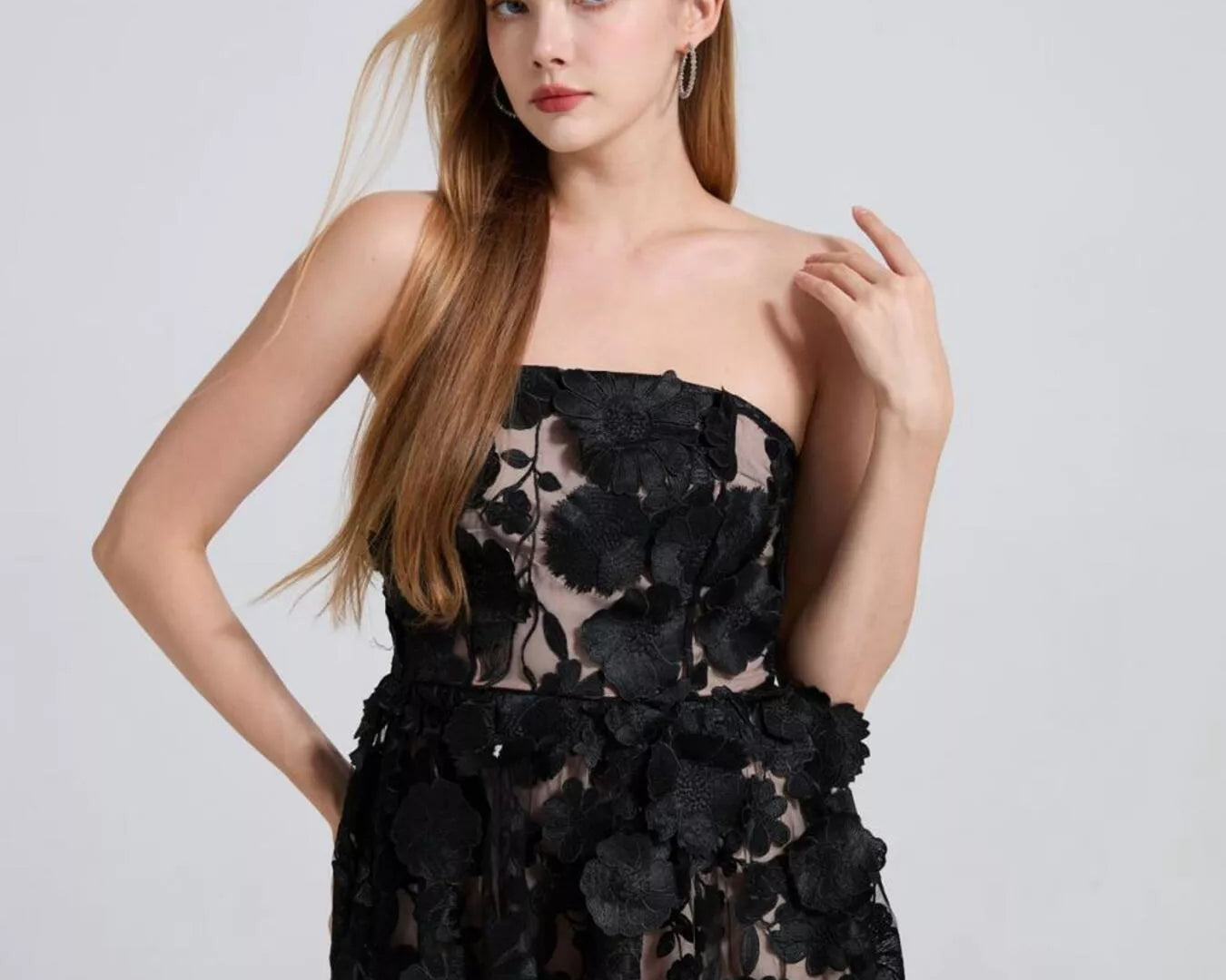 NEWYORKLISTED STYLE COLLECTION: Woman wearing a black floral strapless dress on a light gray background