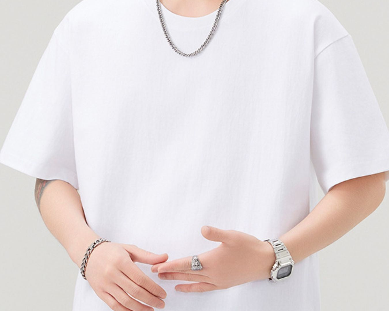 NEWYORKLISTED ATLAS MEN"S COLLECTION: Person wearing a white t-shirt with minimal accessories on a plain background