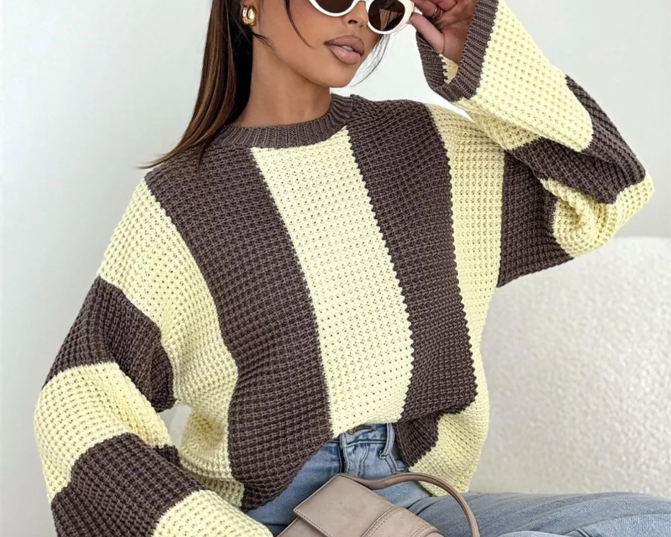 NEWYORKLISTED STYLE COLLECTION: Woman wearing a striped sweater with a neutral background