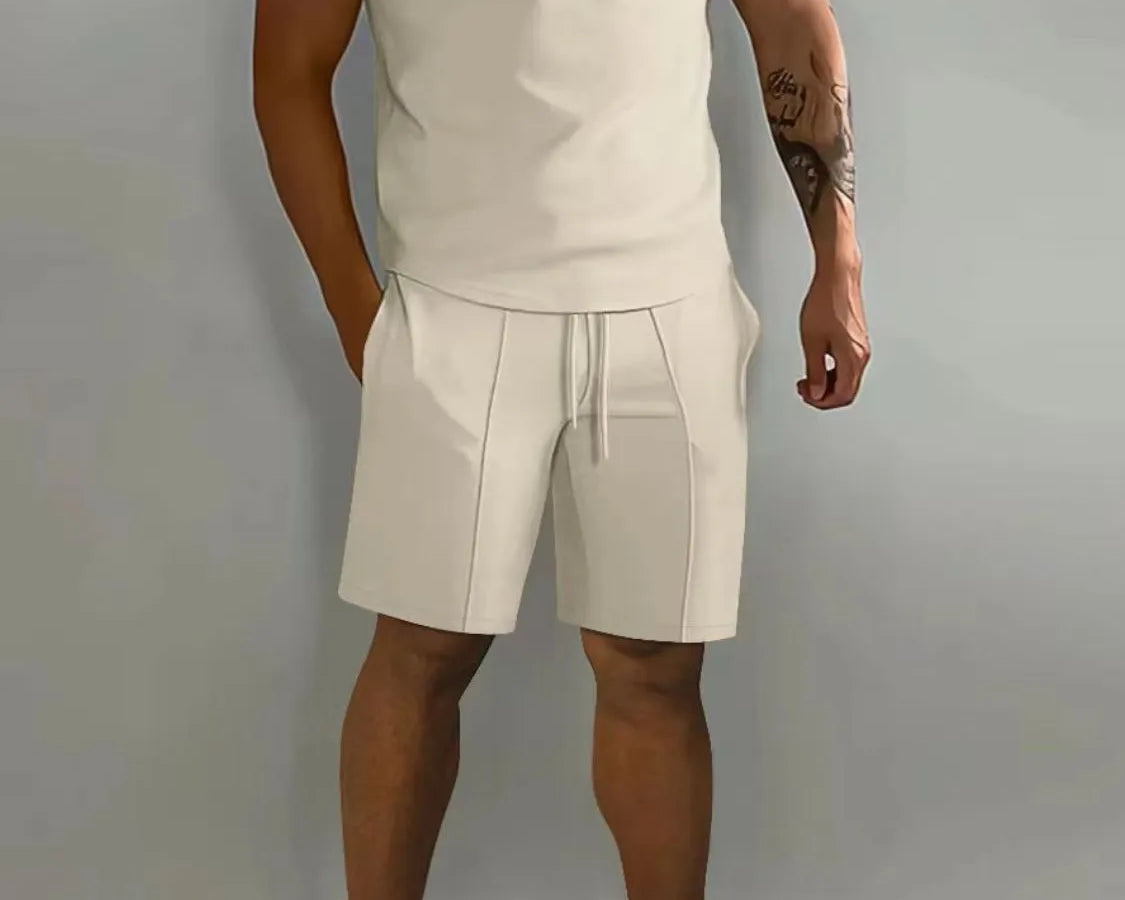 NEWYORKLISTED ATLAS MEN's COLLECTION: Person wearing a beige polo shirt and shorts set with white sneakers on a gray background
