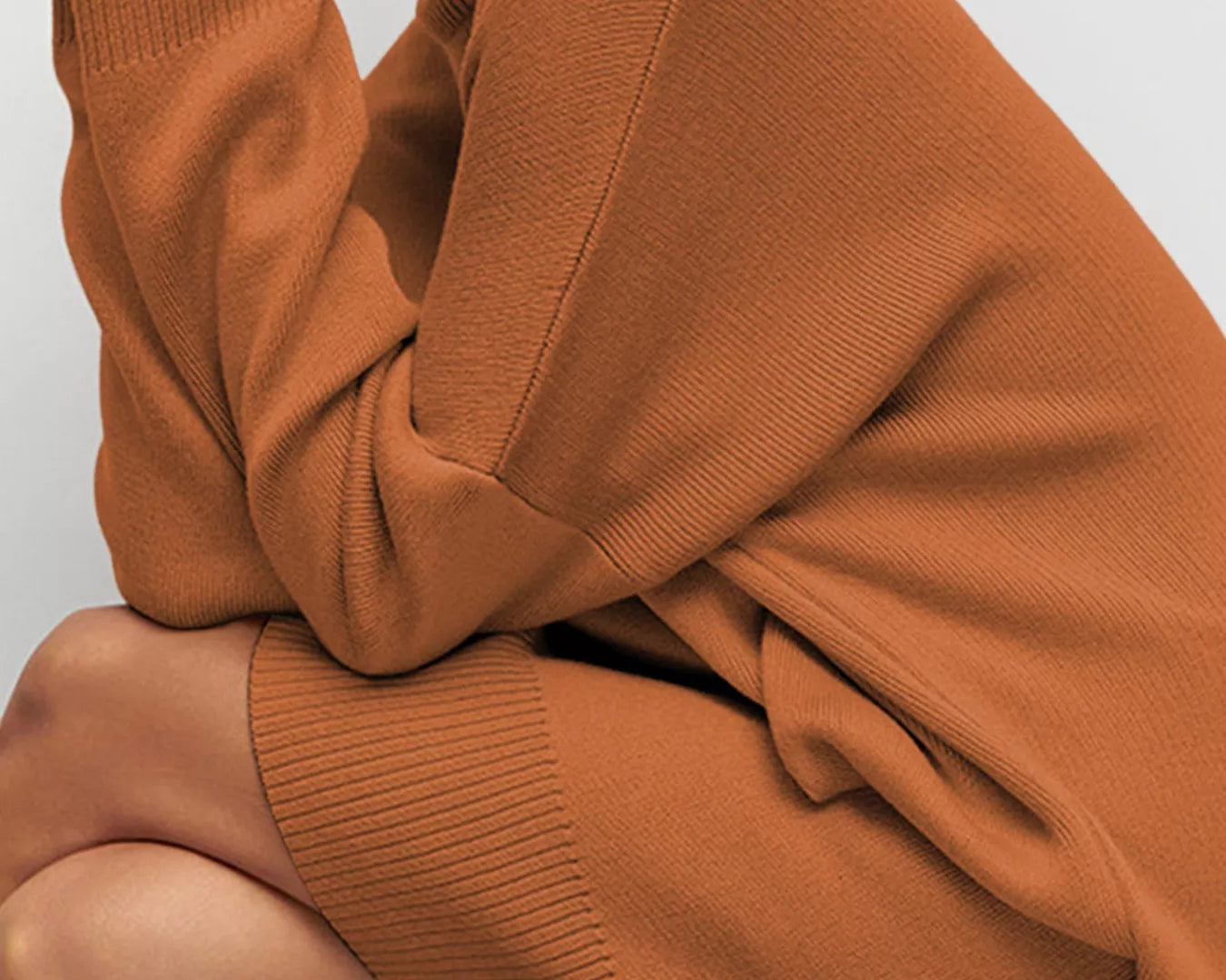 NEWYORKLISTED STYLE COLLECTION: Person wearing a brown sweater with a plain background