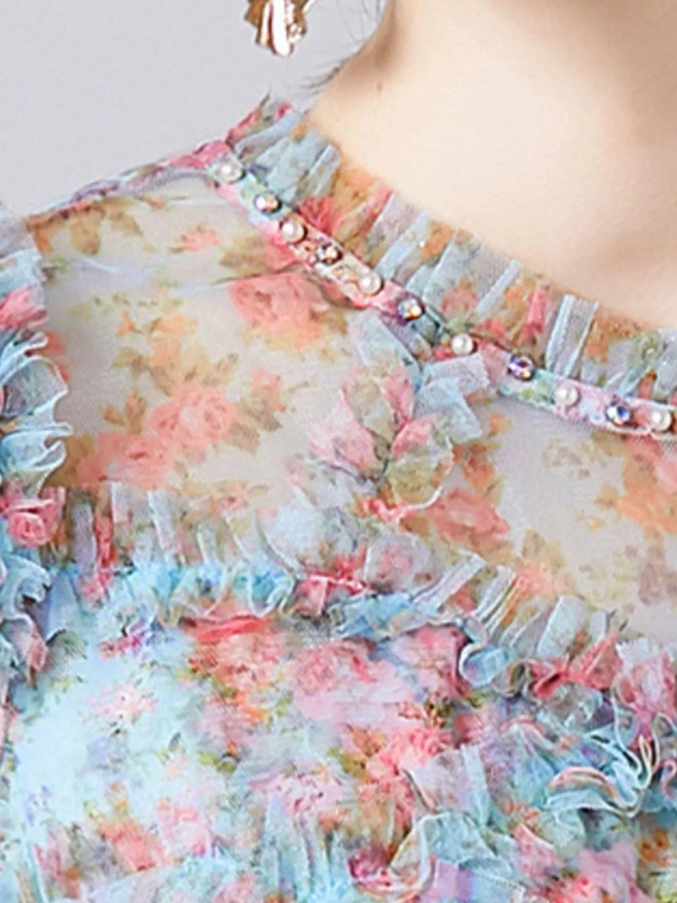 NEWYORKLISTED STYLE COLLECTION: Floral dress with ruffled details and pearl embellishments on a blurred background