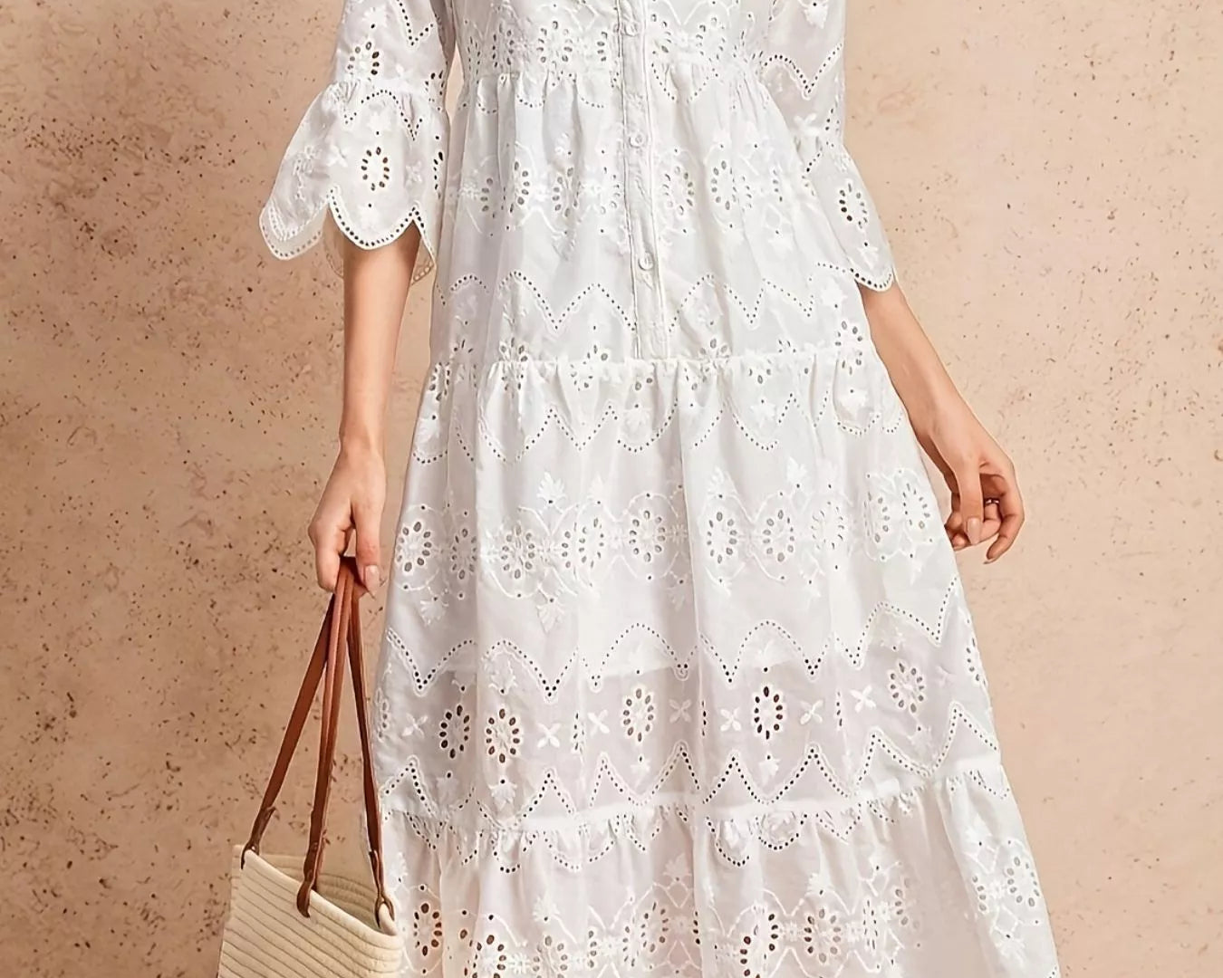 NEWYORKLISTED STYLE COLLECTION: Woman wearing a white lace dress holding a straw bag against a beige background