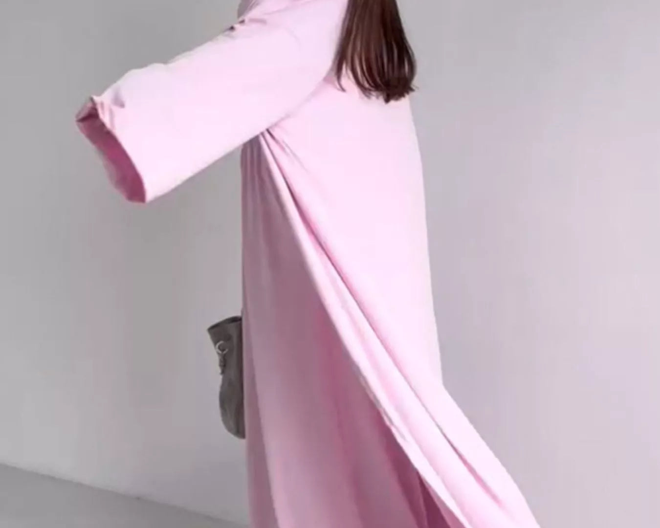 NEWYORKLISTED COMFORT COLLECTION: Woman wearing a long pink off-shoulder dress against a plain background