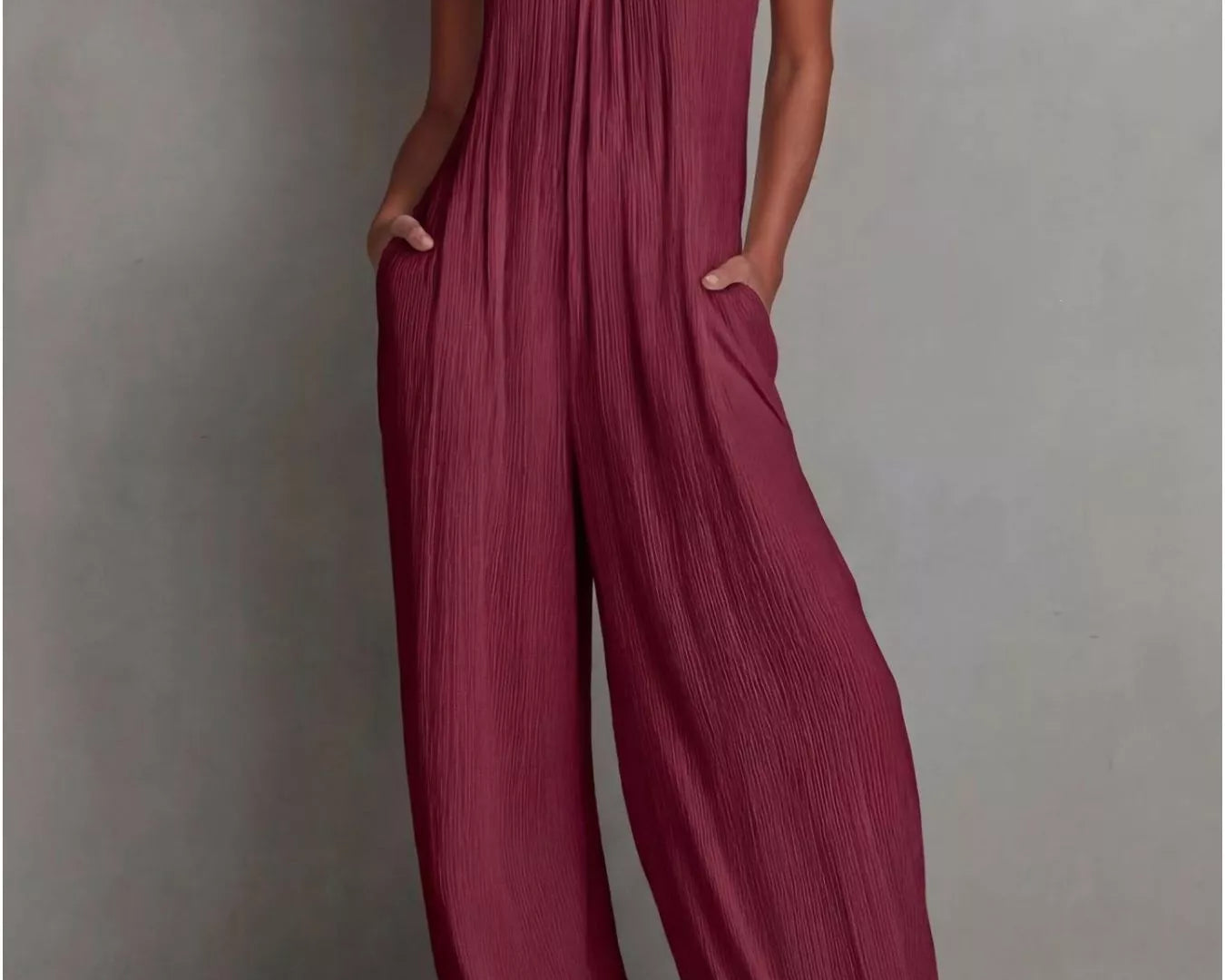NEWYORKLISTED STYLE COLLECTION: Woman wearing a burgundy jumpsuit against a gray background