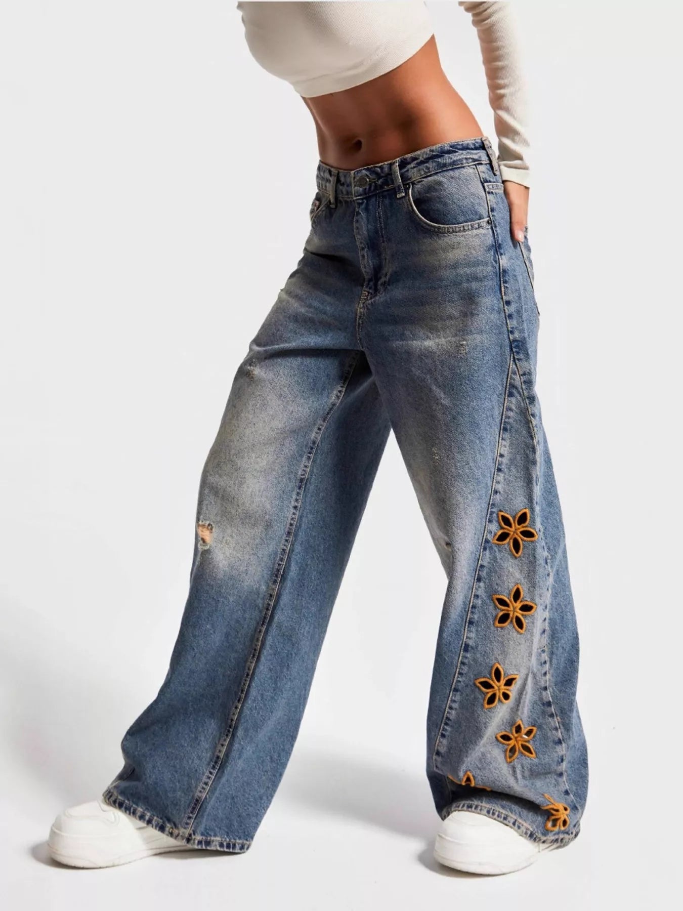NEWYORKLISTED STYLE COLLECTION: Wide-leg jeans with floral embellishments on a white background