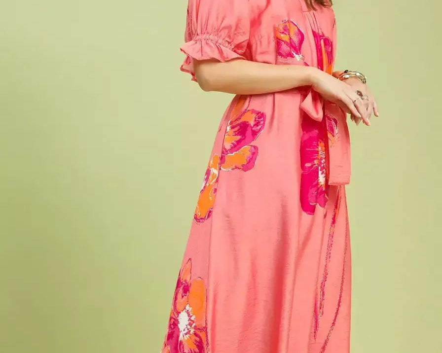 NEWYORKLISTED STYLE COLLECTION: Woman wearing a pink dress with floral patterns on a light green background