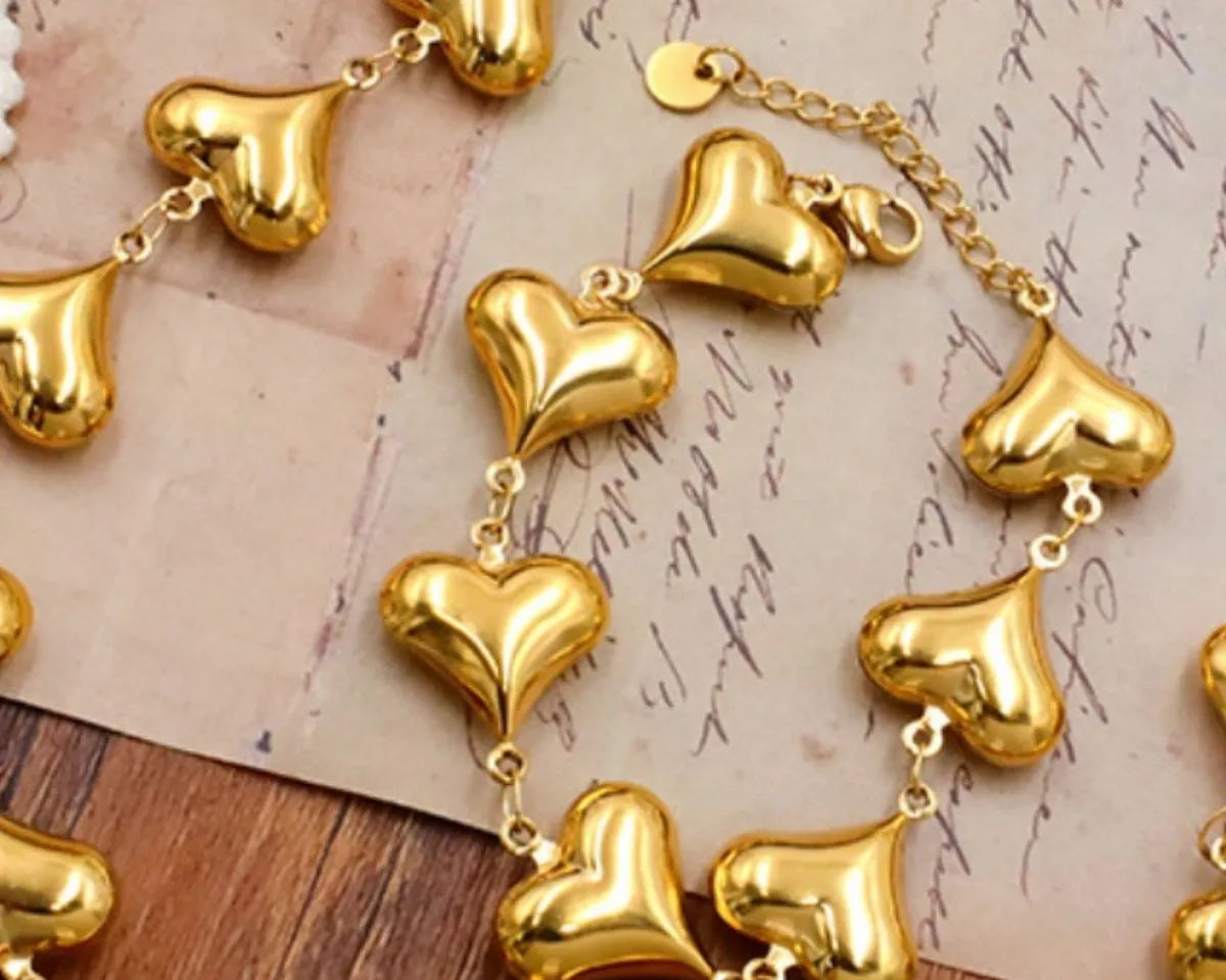 NYLD Glamour Collection by NEWYORKLISTED: Gold heart-shaped bracelet on a textured surface