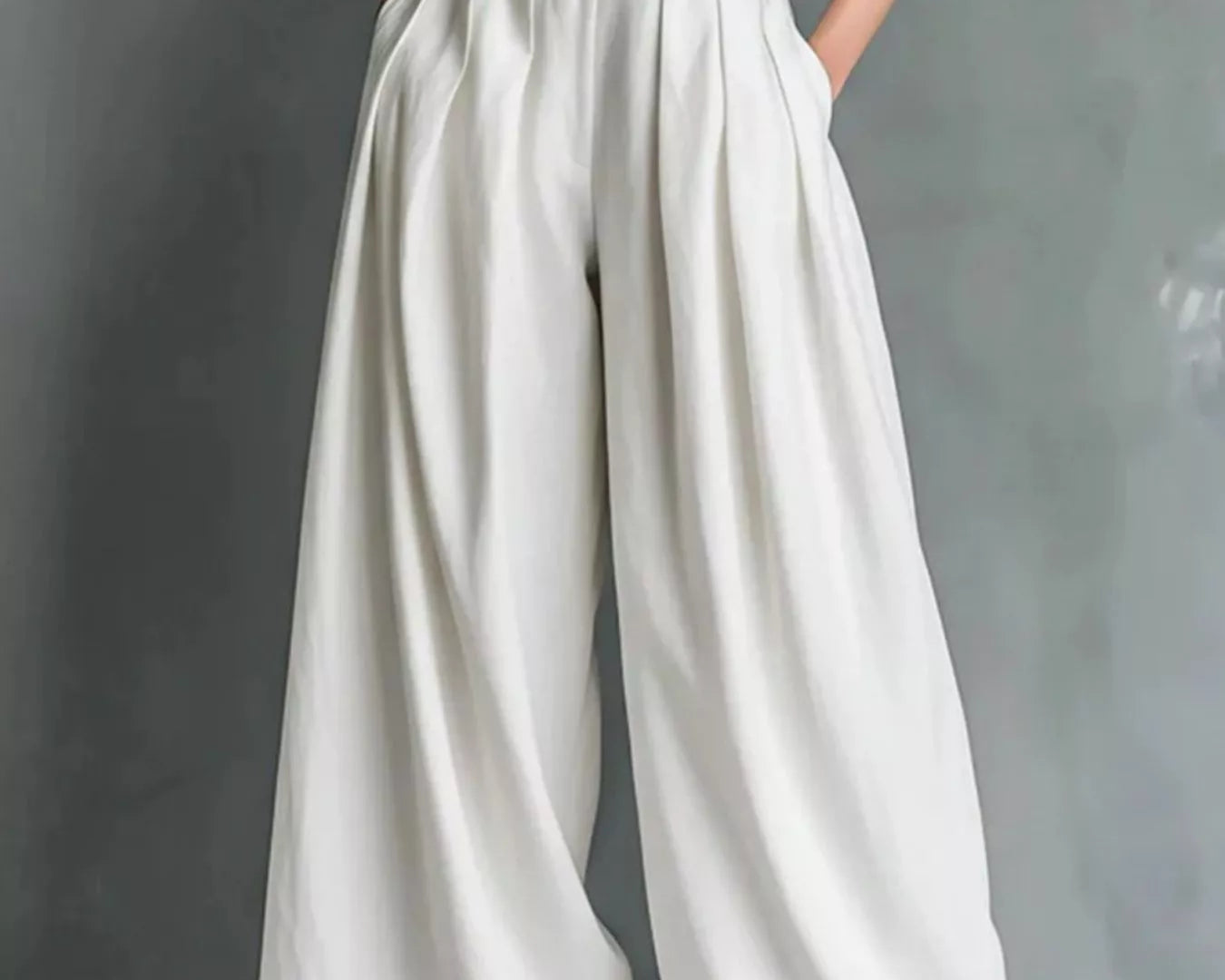 NEWYORKLISTED STYLE COLLECTION: White wide-leg pants worn with a black top on a gray background