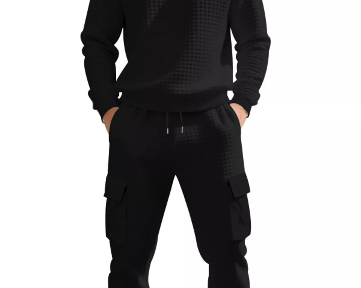 NEWYORKLISTED ATLAS MEN'S COLLECTION: A man wearing a black long-sleeve crewneck sweatshirt and matching black cargo jogger pants with a subtle geometric pattern, shown against a plain white background.