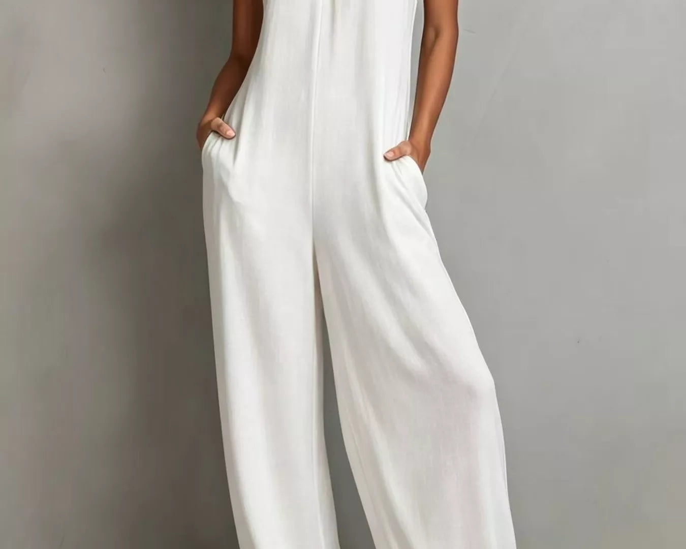 NEWYORKLISTED STYLE COLLECTION: Woman wearing a white jumpsuit against a plain background