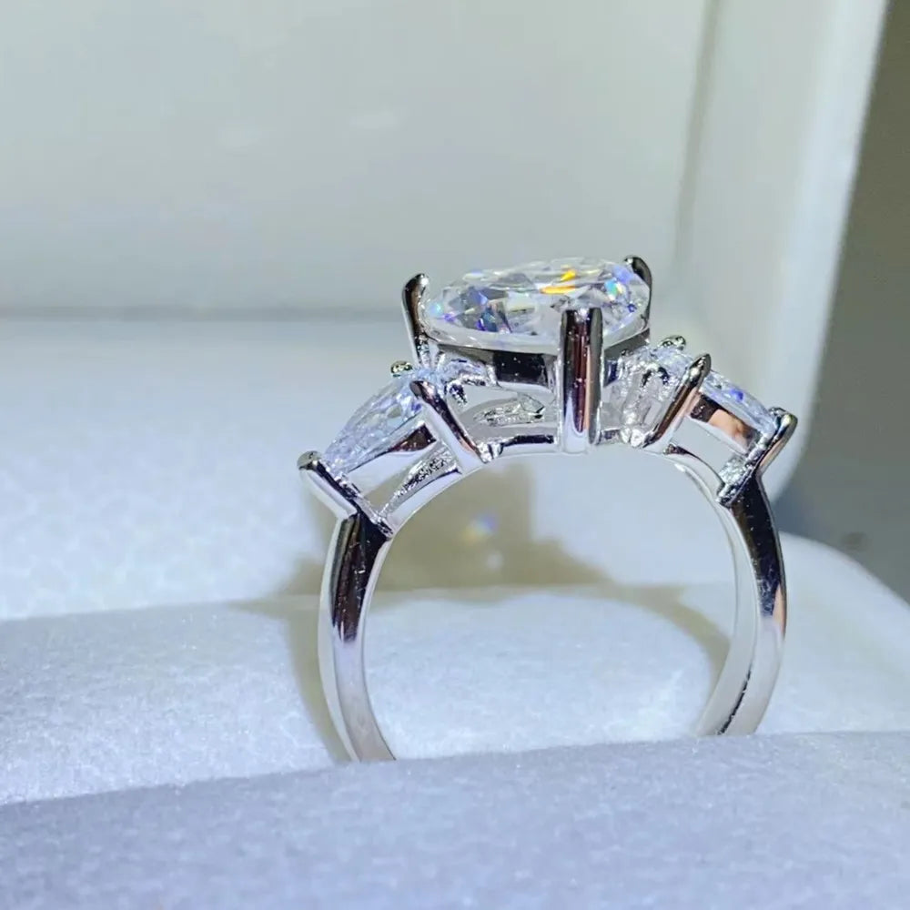 NYLD Glamour Collection By NEWYORKLISTED: Silver ring with a large central diamond and smaller side stones on a white background
