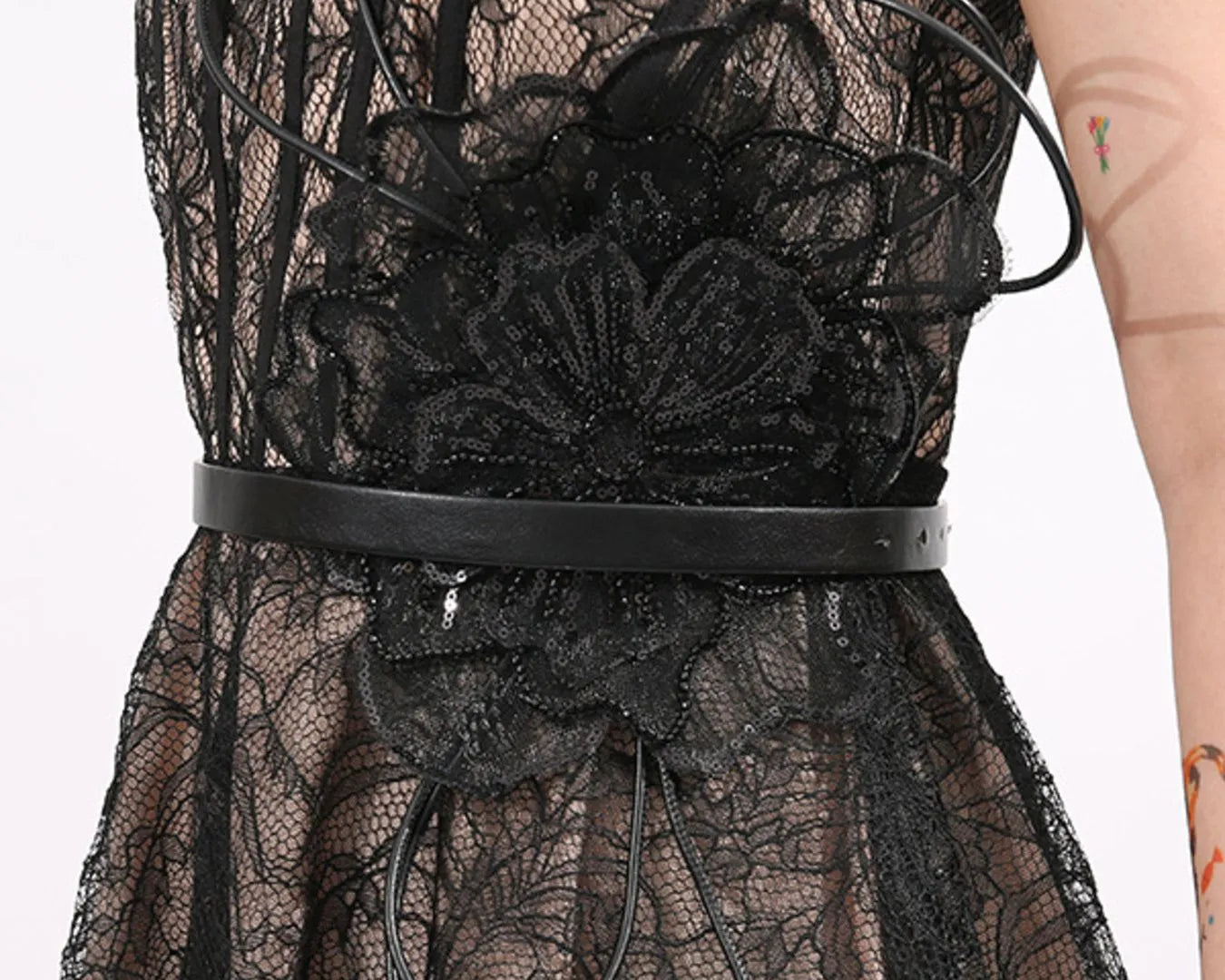 NEWYORKLISTED RUNWAY STYLE: Black lace dress with a belt on a white background