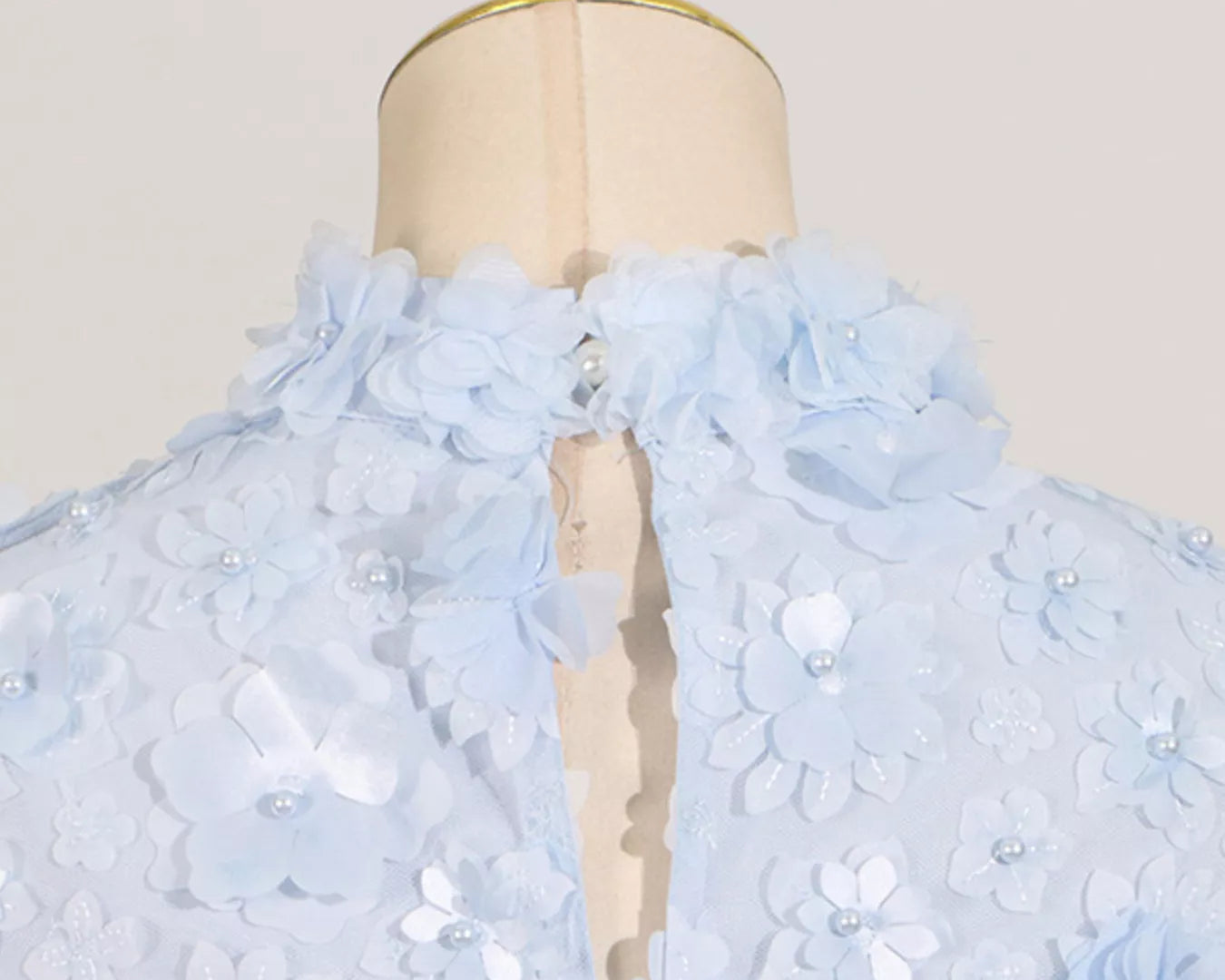 NEWYORKLISTED STYLE COLLECTION: Light blue floral dress on a mannequin with a plain background