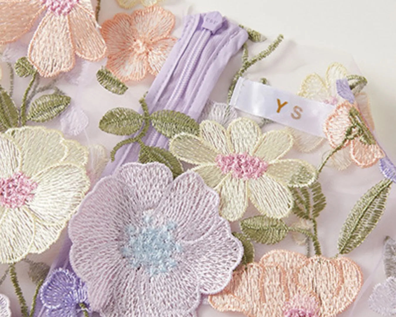 NEWYORKLISTED STYLE COLLECTION: Embroidered floral designs on fabric with a visible brand tag.