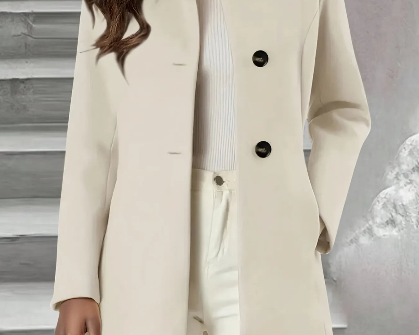 NEWYORKLISTED STYLE COLLECTION: Beige coat with black buttons worn by a person against a neutral background