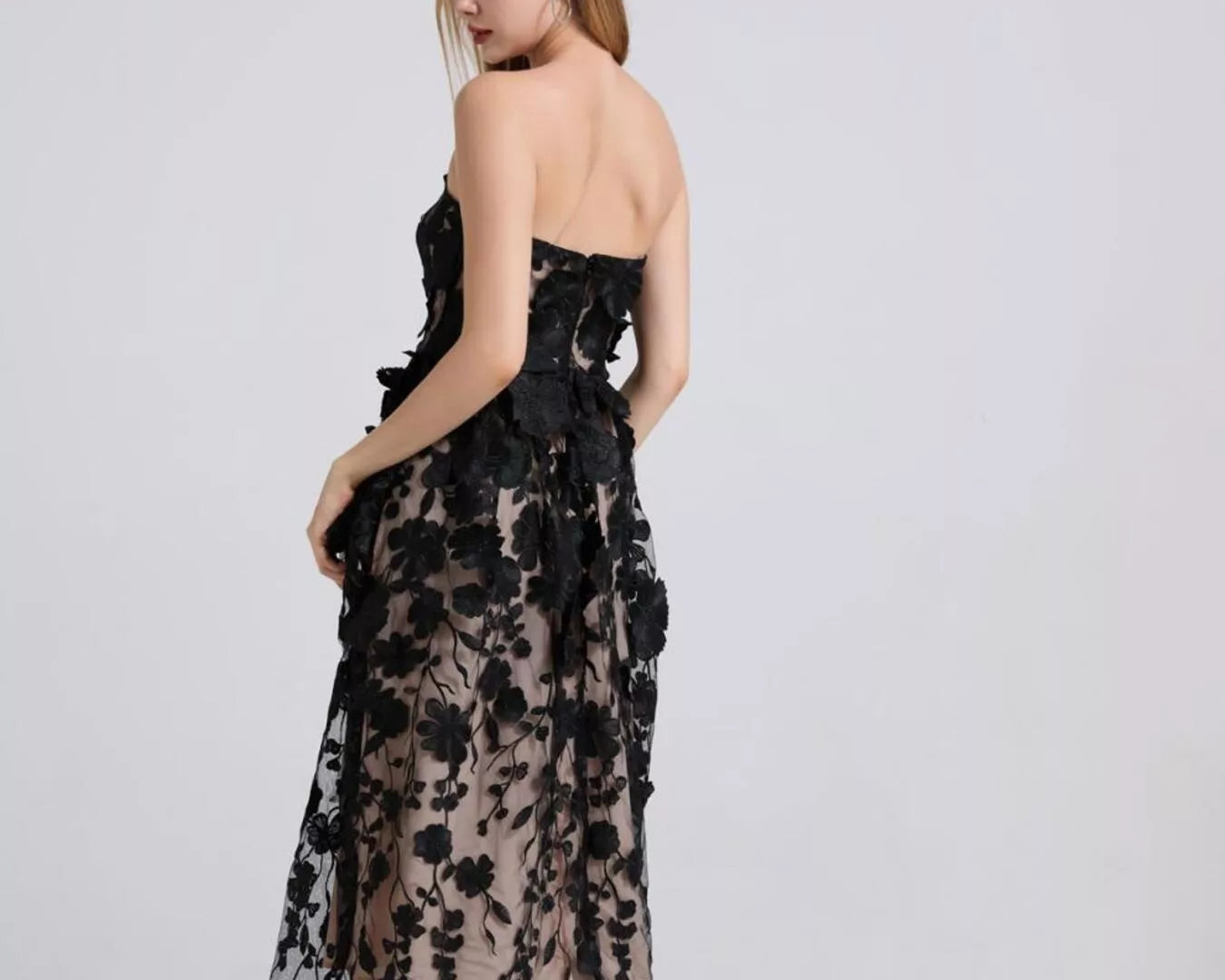 NEWYORKLISTED STYLE COLLECTION: Woman wearing a black floral dress on a white background