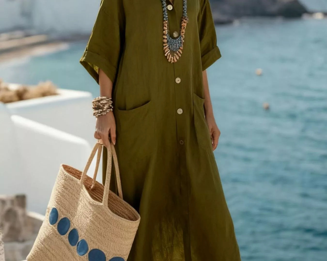 NEWYORKLISTED STYLE COLLECTION: Woman in an olive green outfit with a straw bag by the ocean