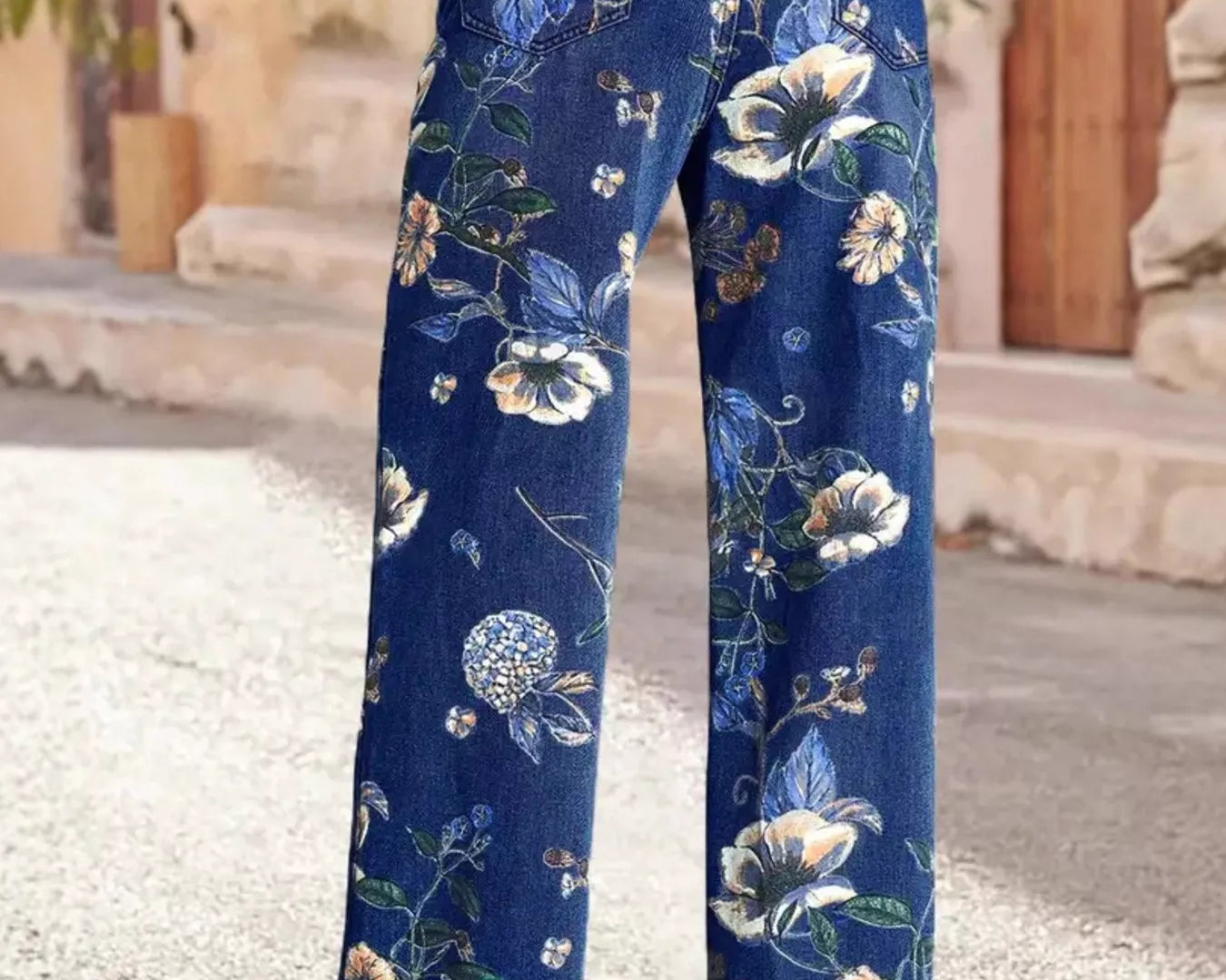 NEWYORKLISTED STYLE COLLECTION: Blue floral pants worn by a person on a stone pavement.