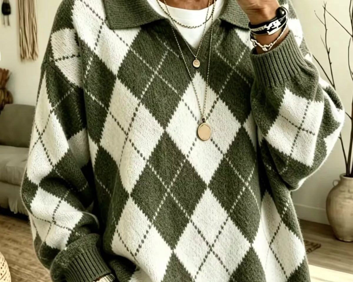 NEWYORKLISTED STYLE COLLECTION: A woman takes a mirror selfie wearing an oversized knit polo sweater with an olive green and white argyle pattern, layered over a white t-shirt and paired with light-wash jeans.