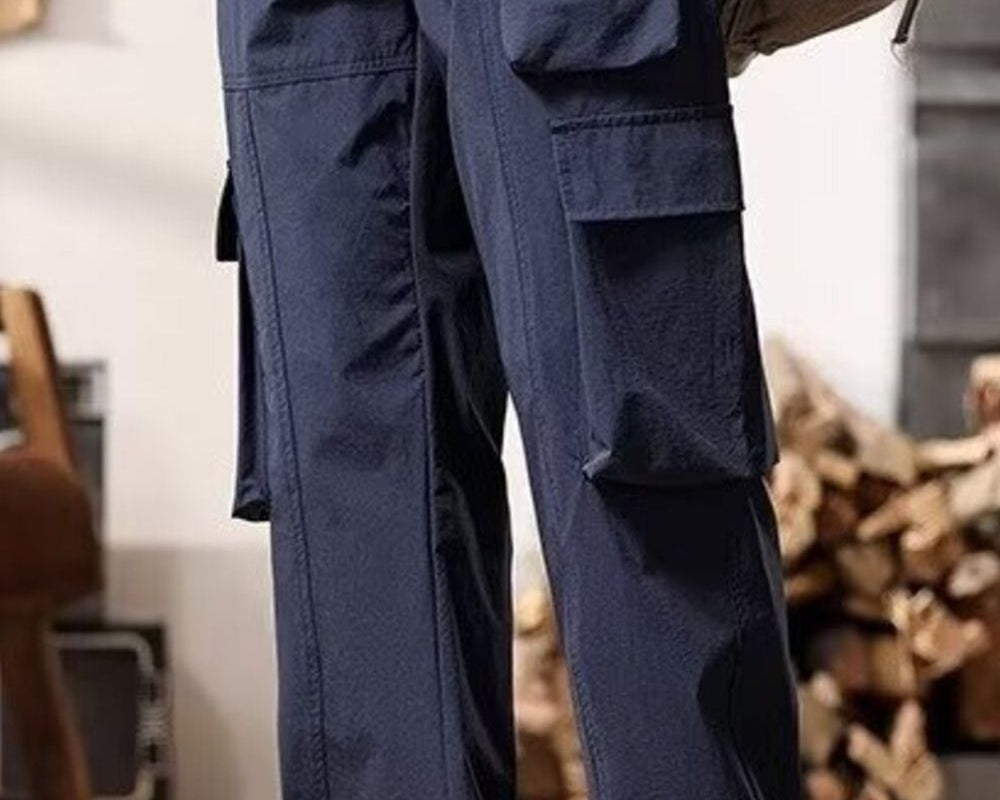 NEWYORKLISTED ATLAS MEN's COLLECTION: Person wearing navy cargo pants with a blurred background