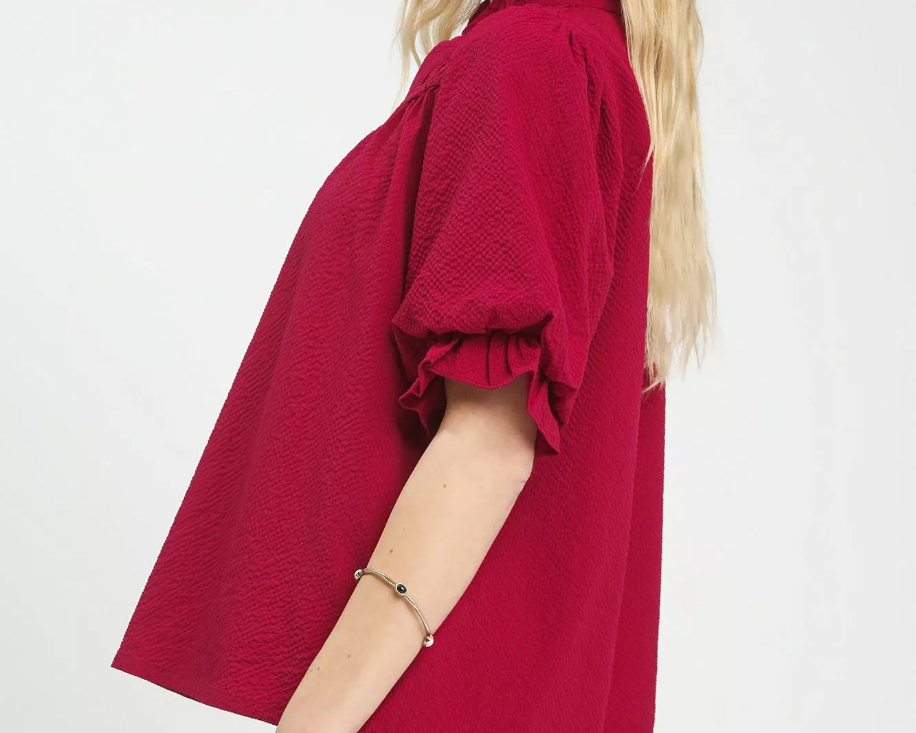 NEWYORKLISTED Style Collection: Woman wearing a red blouse with ruffled sleeves on a white background