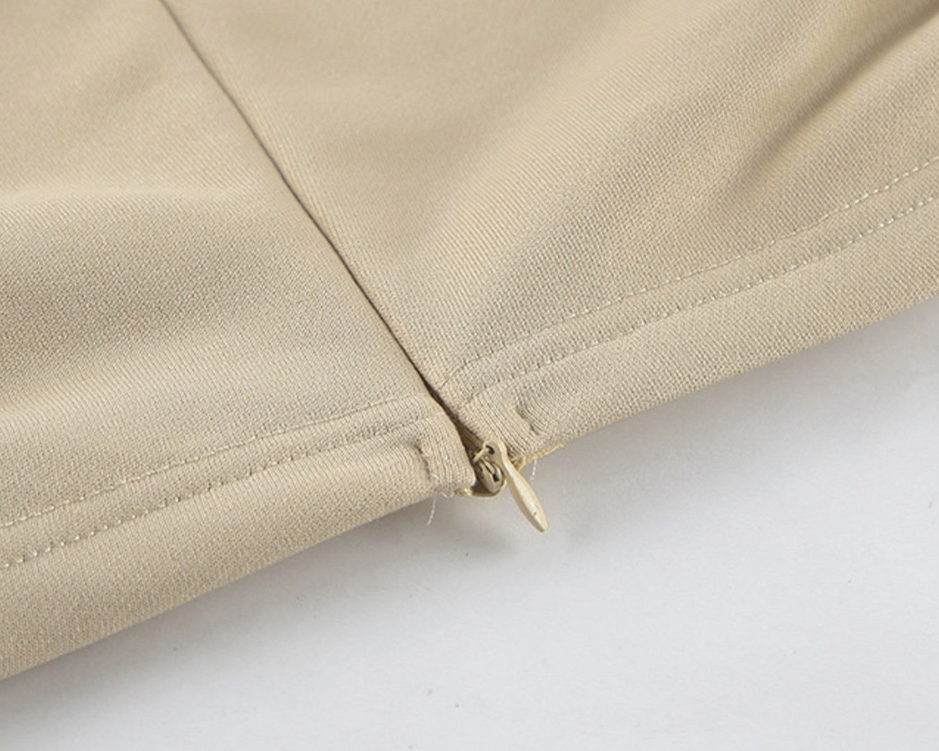 NEWYORKLISTED STYLE COLLECTION: Close-up of beige fabric with a zipper on a white background