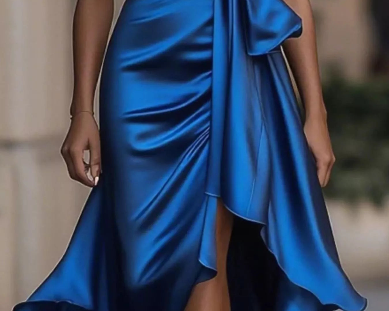 NEWYORKLISTED STYLE COLLECTION: Blue satin dress with a tie waist on a blurred background