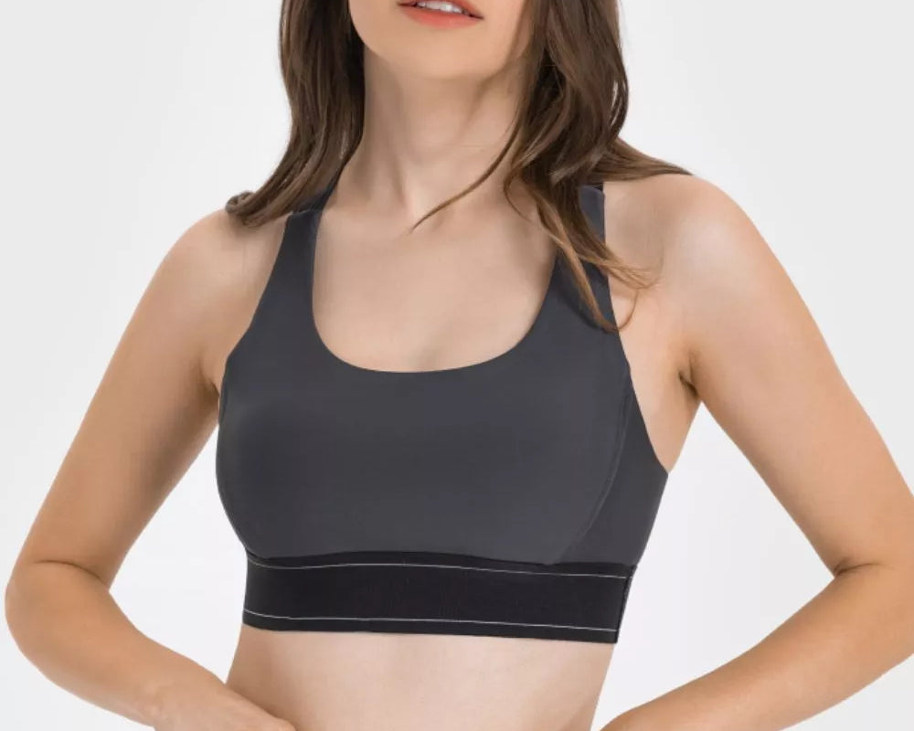 NEWYORKLISTED ACTIVEWEAR COLLECTION: Woman wearing a black sports bra and leggings on a white background