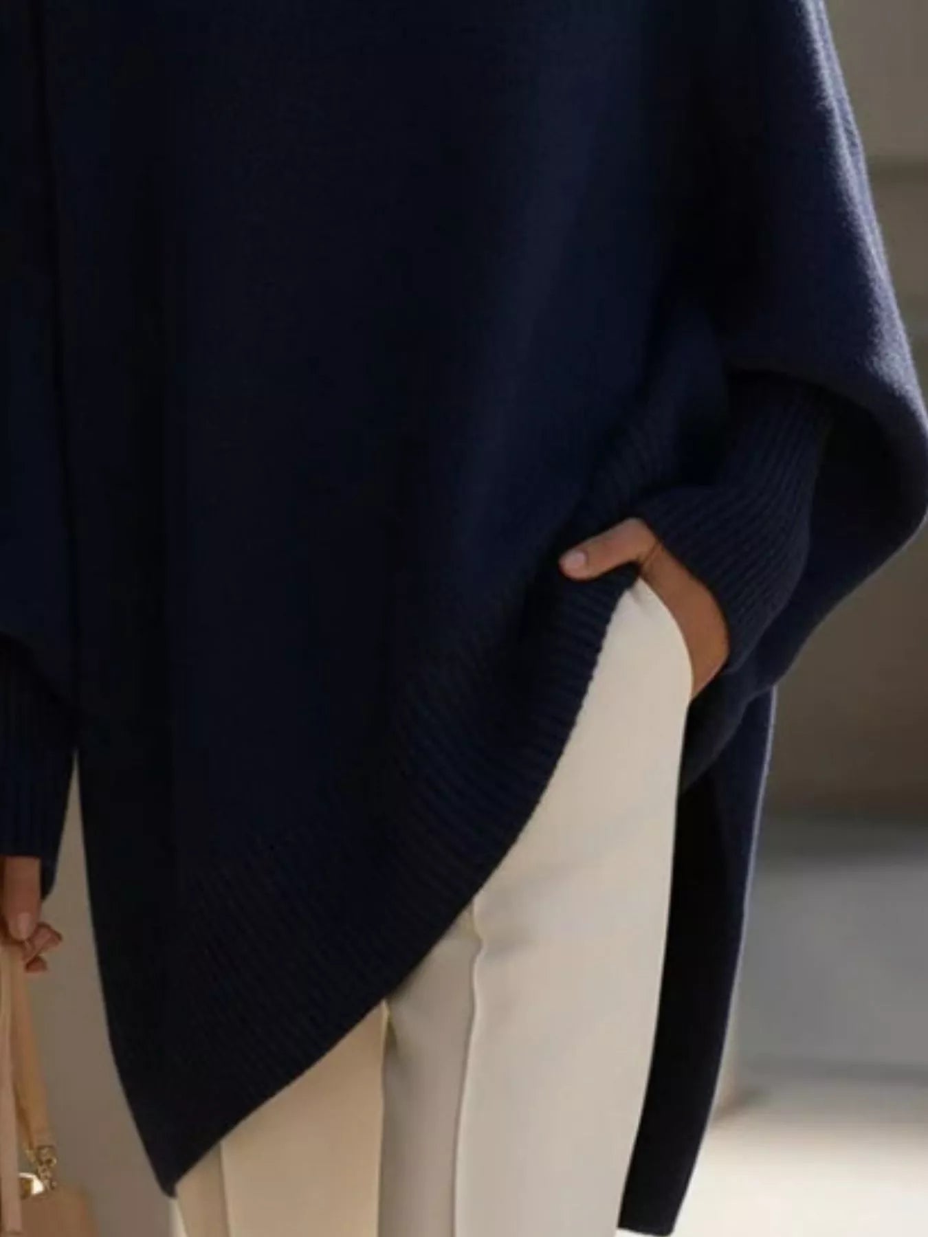 NEWYORKLISTED STYLE COLLECTION: Person wearing a navy blue sweater with a blurred background