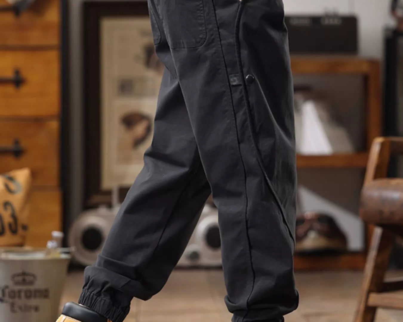 NEWYORKLISTED ATLAS MEN'S COLLECTION: Person wearing dark cargo pants and yellow boots in a casual indoor setting