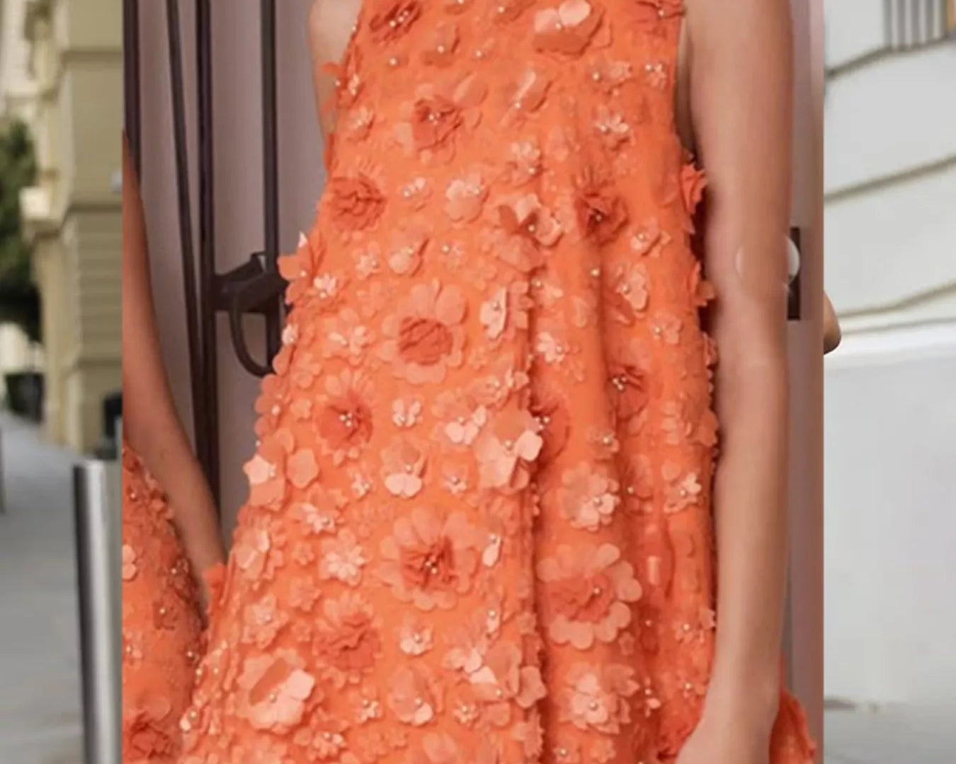 NEWYORKLISTED STYLE COLLECTION: Woman wearing an orange floral dress with a blurred background