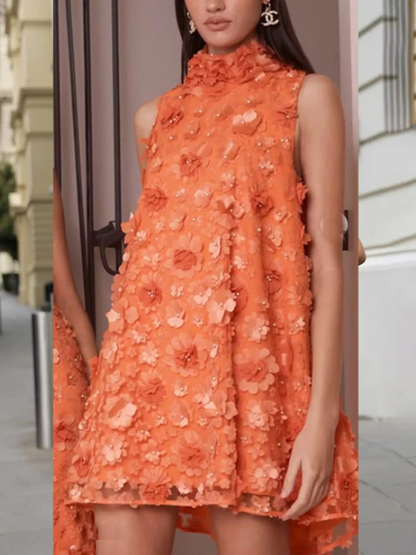 NEWYORKLISTED STYLE COLLECTION: Woman wearing an orange floral dress with a blurred background
