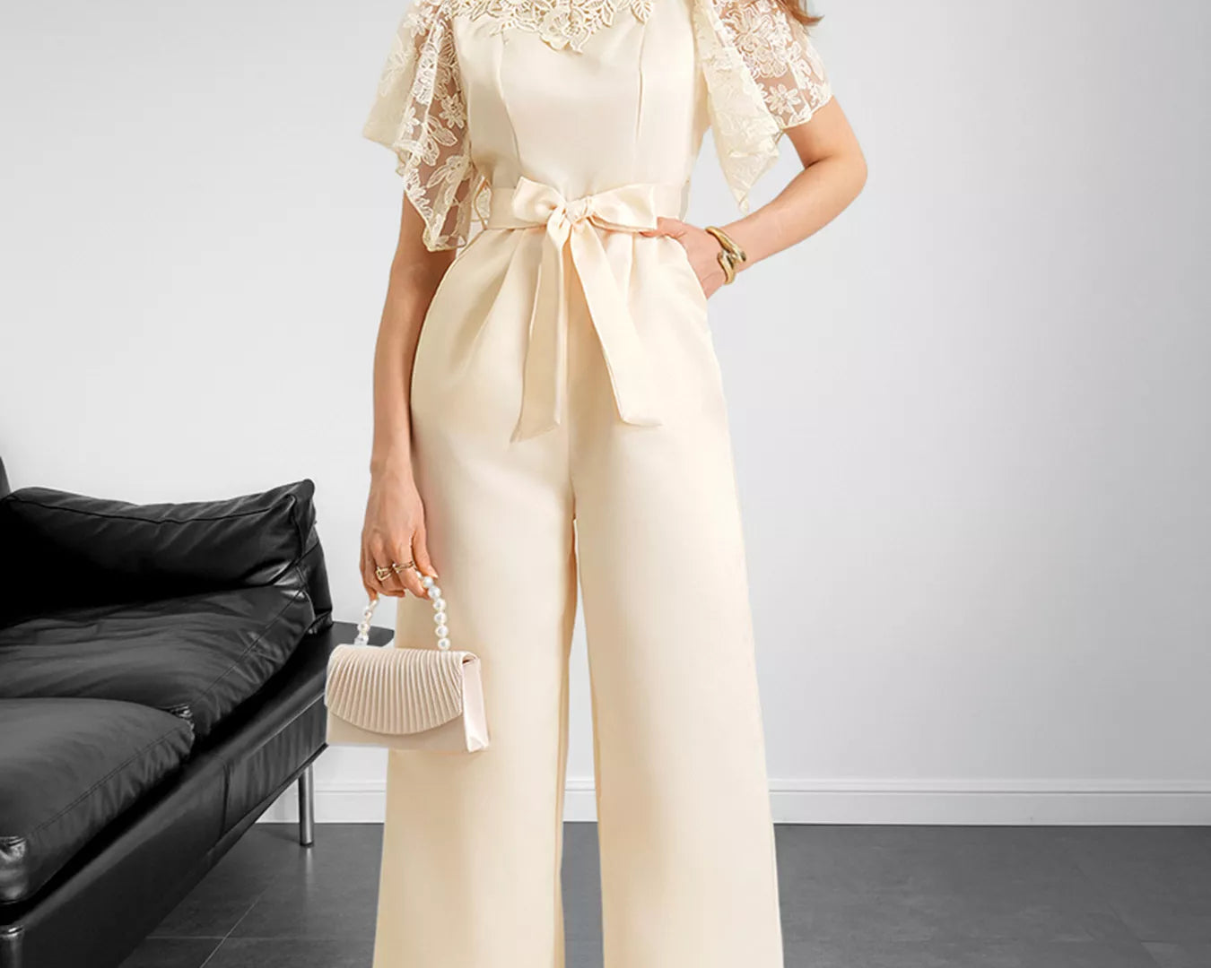 NEWYORKLISTED STYLE COLLECTION: Woman wearing a beige outfit with lace details in a minimalistic room.