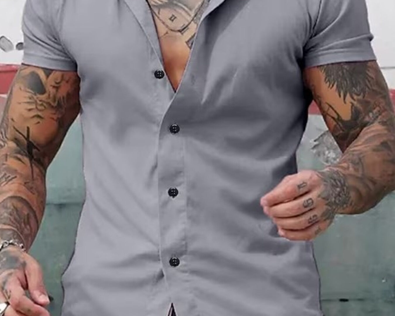 NEWYORKLISTED ATLAS MEN's COLLECTION: Man wearing a gray button-up shirt with tattoos on his arms.