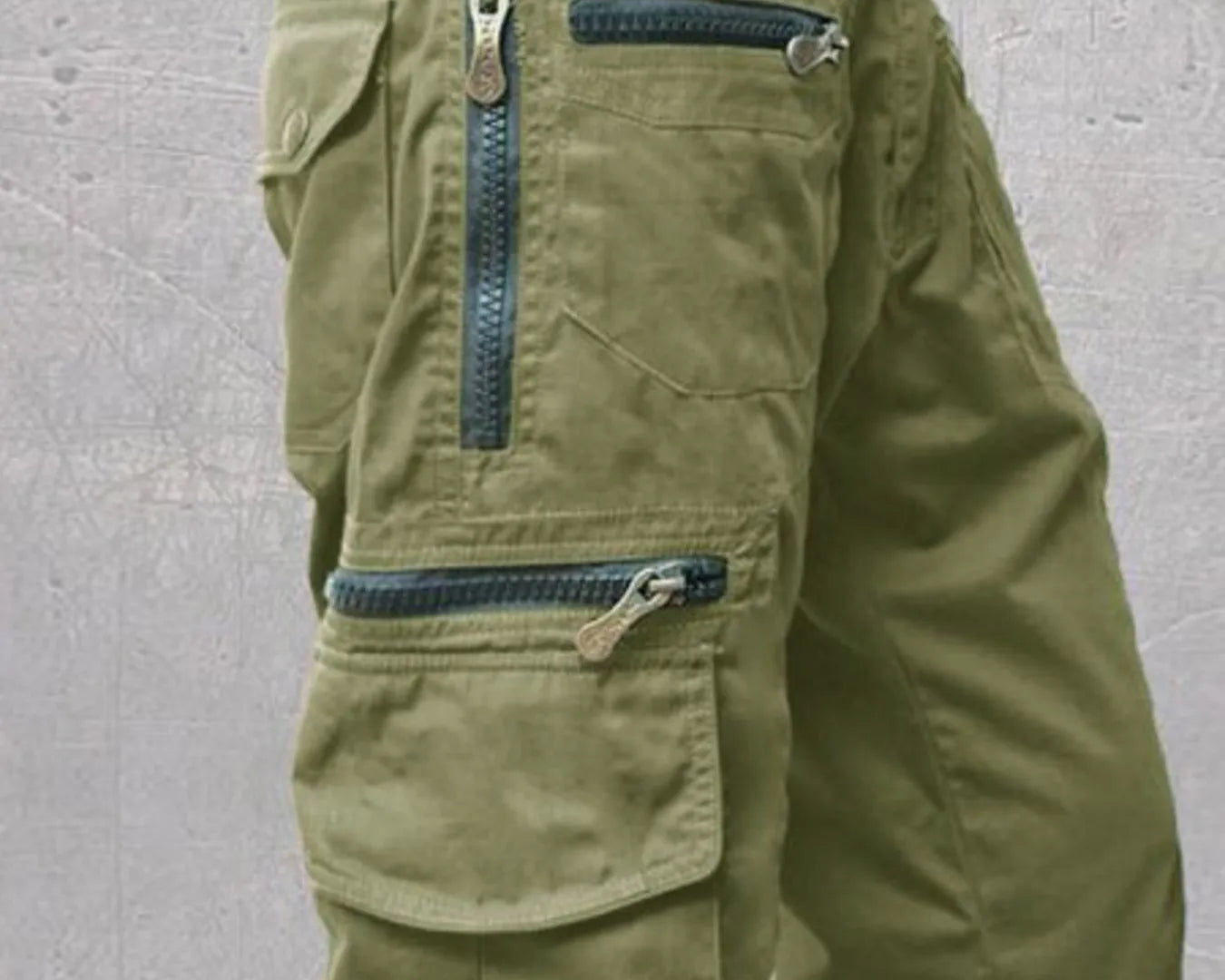 NEWYORKLISTED ATLAS MEN'S COLLECTION: Green cargo shorts with multiple pockets and zippers on a gray background