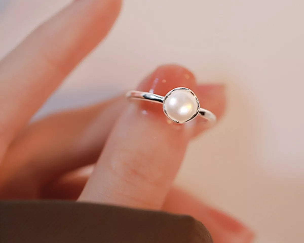 NYLD Glamour By NEWYORKLSITED: Sterling silver ring with freshwater pearl stone on a blurred background
